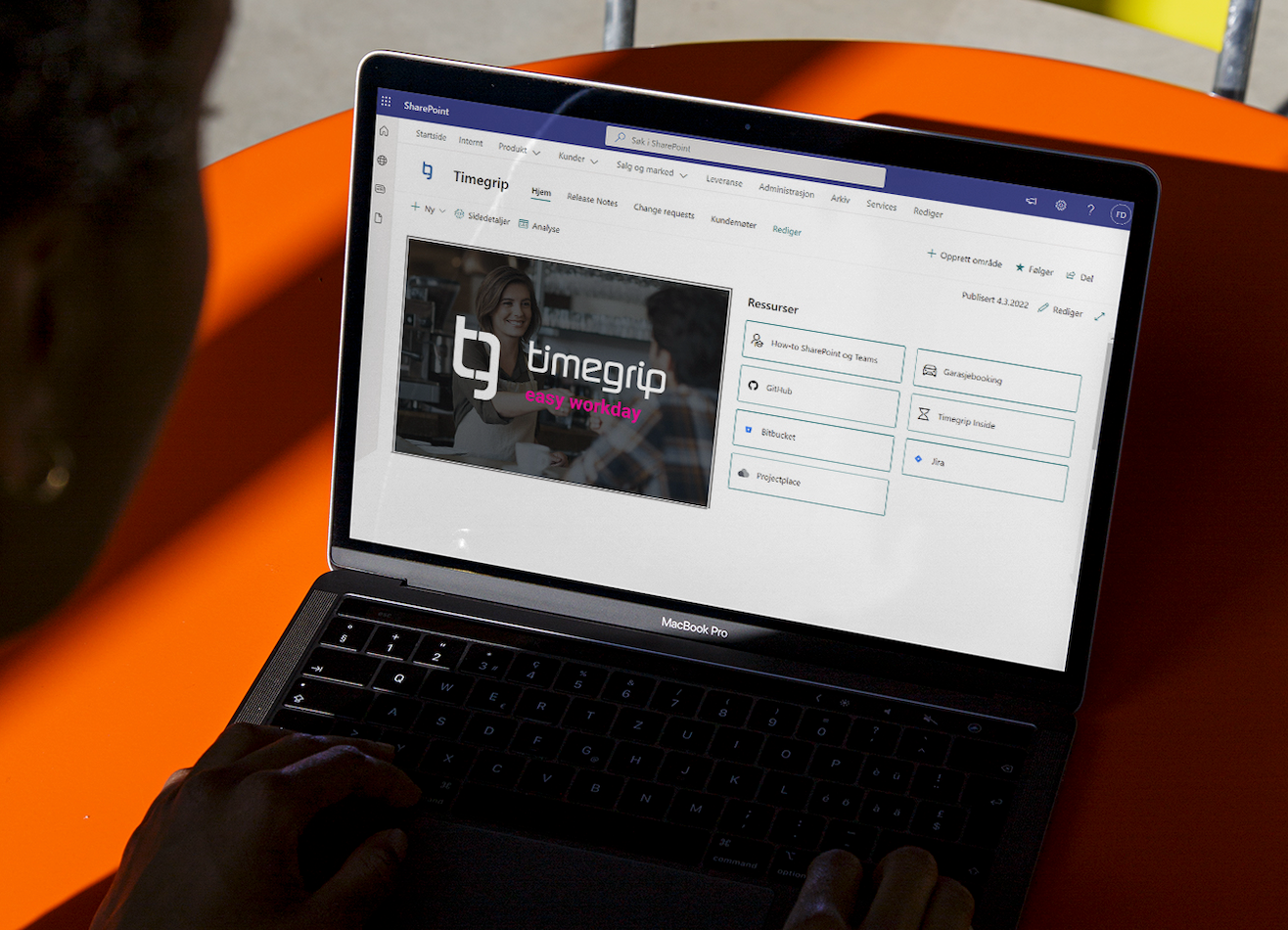 En person skriver på en MacBook Pro som viser SharePoint med Timegrip-logoen og ressurser på skjermen.