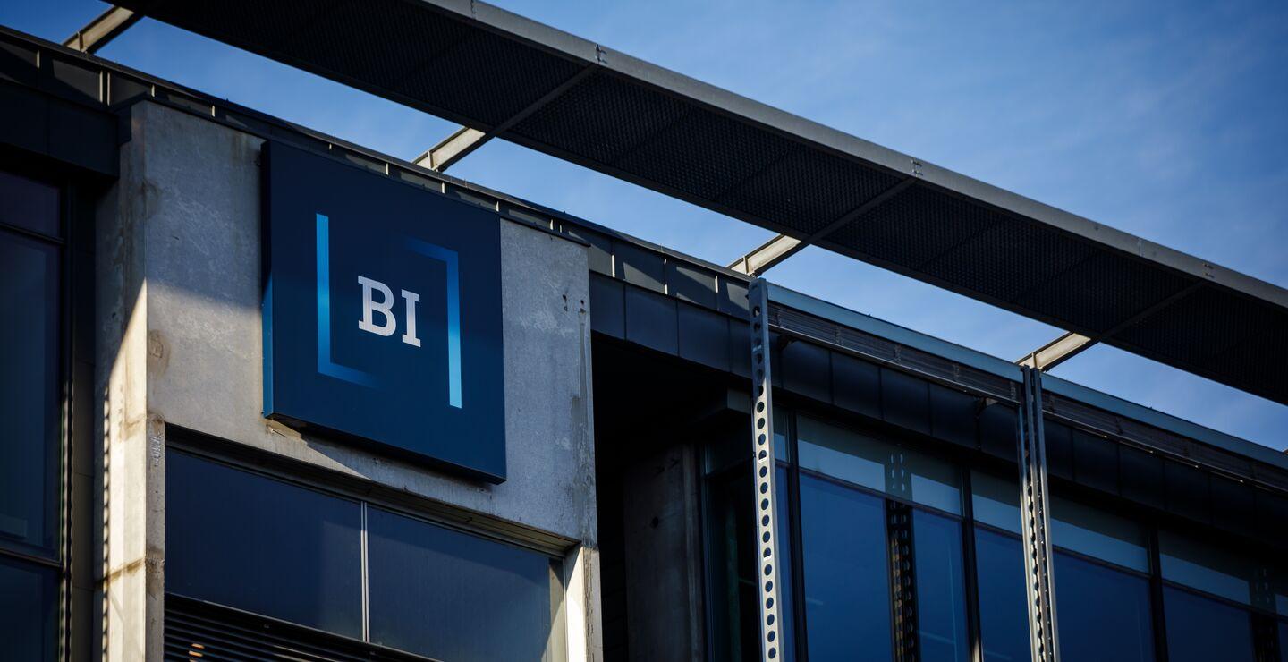 BI-logo på en bygning under blå himmel.