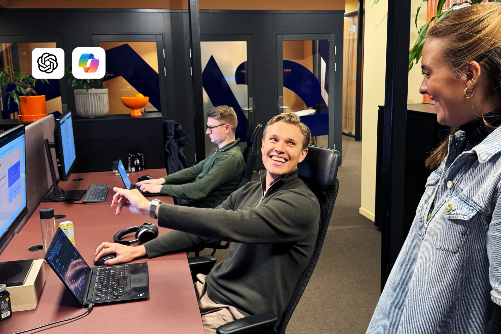 En smilende mann strekker ut hånden, omgitt av kolleger i et moderne kontorlandskap, med ChatGPT- og Copilot-logoer øverst til venstre.