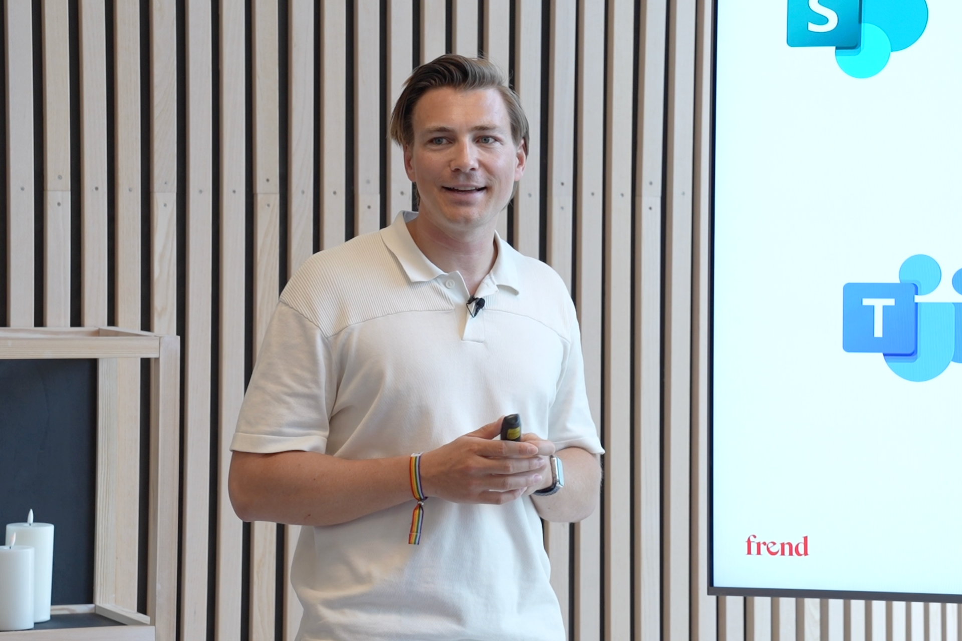 En smilende mann presenterer på et seminar om internkommunikasjon, med Microsoft Teams-logoen synlig på en skjerm.