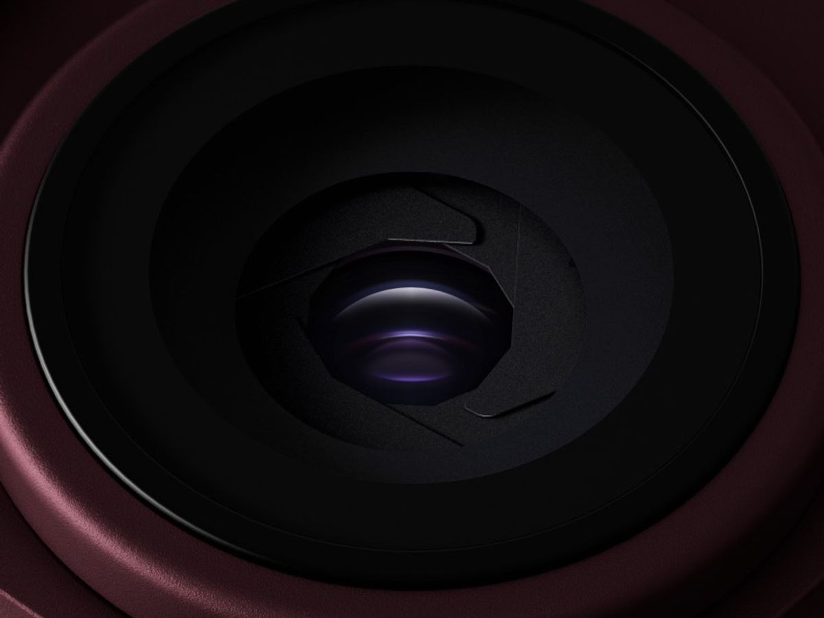 Close-up of a variable camera aperture set into a dark burgundy camera housing.