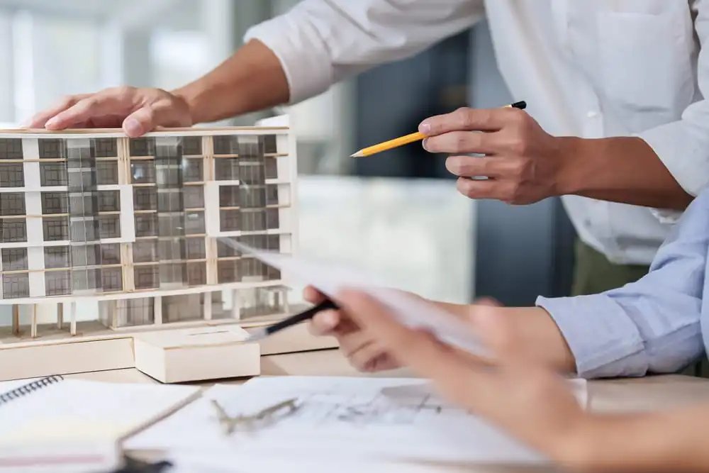Architect reviewing construction plans in the Charleston SC area where both general liability and professional liability insurance may be needed for design-build projects.
