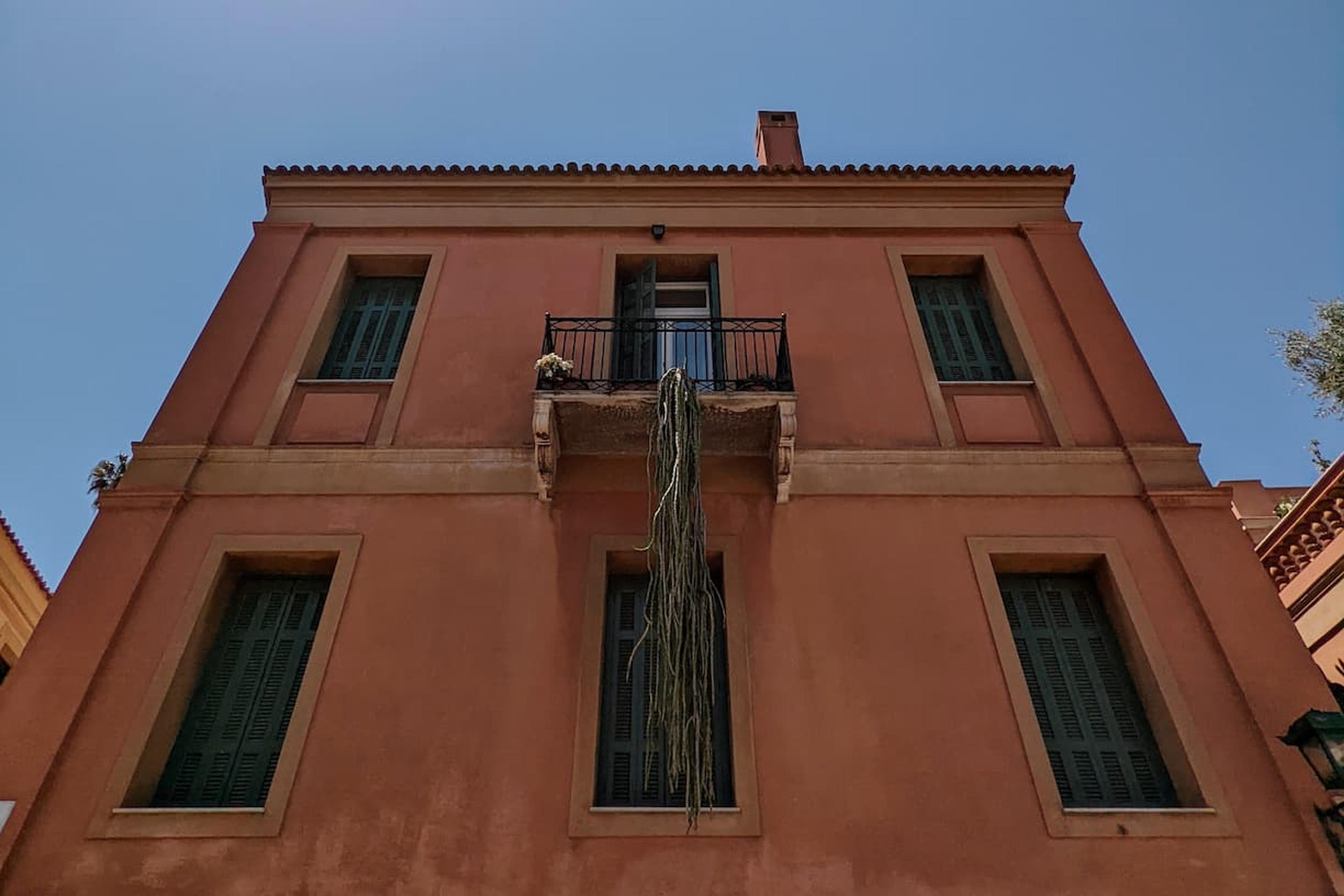 house with cactus hanging from balcony