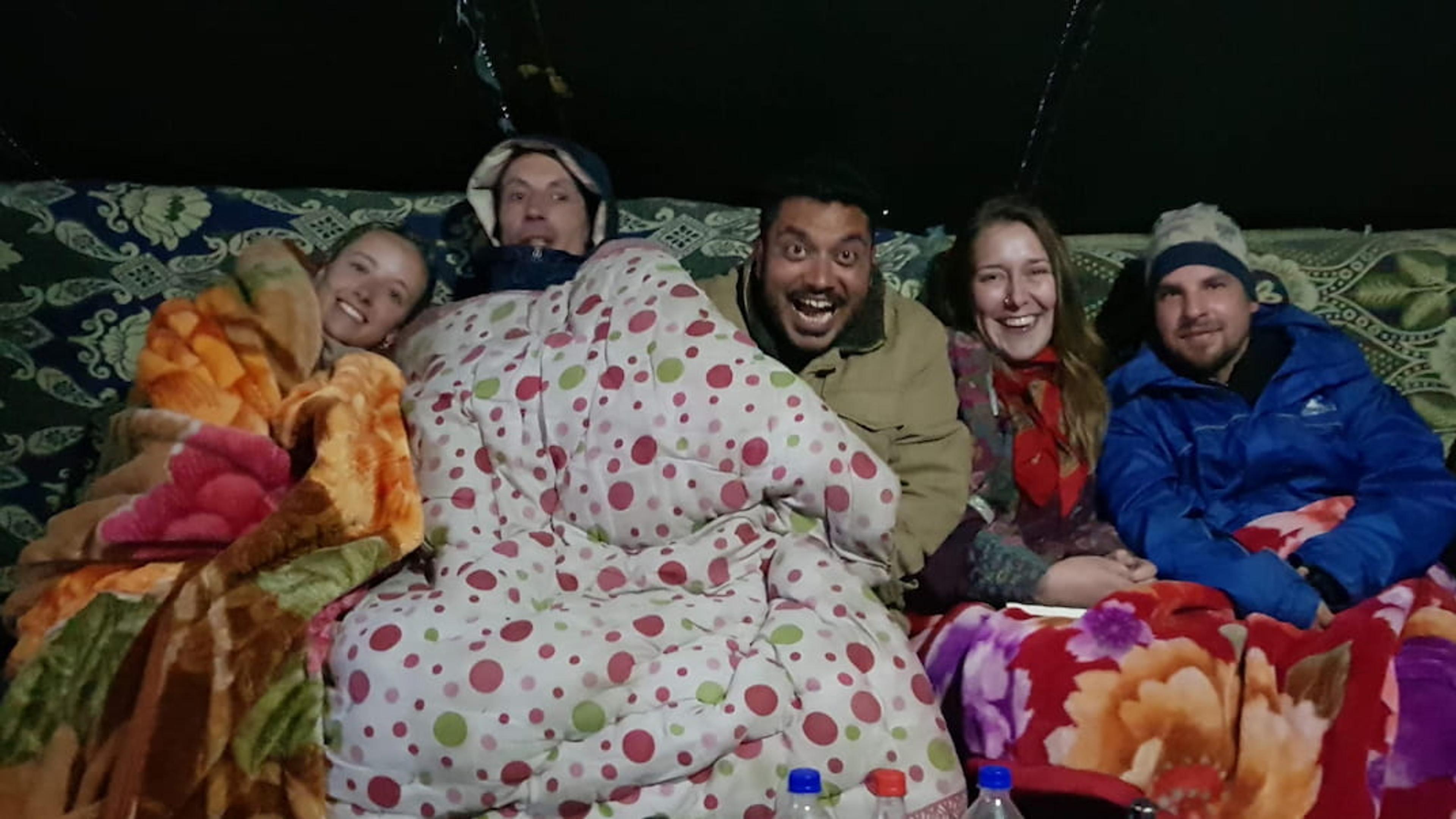 at the campsite wrapped in blankets against the cold