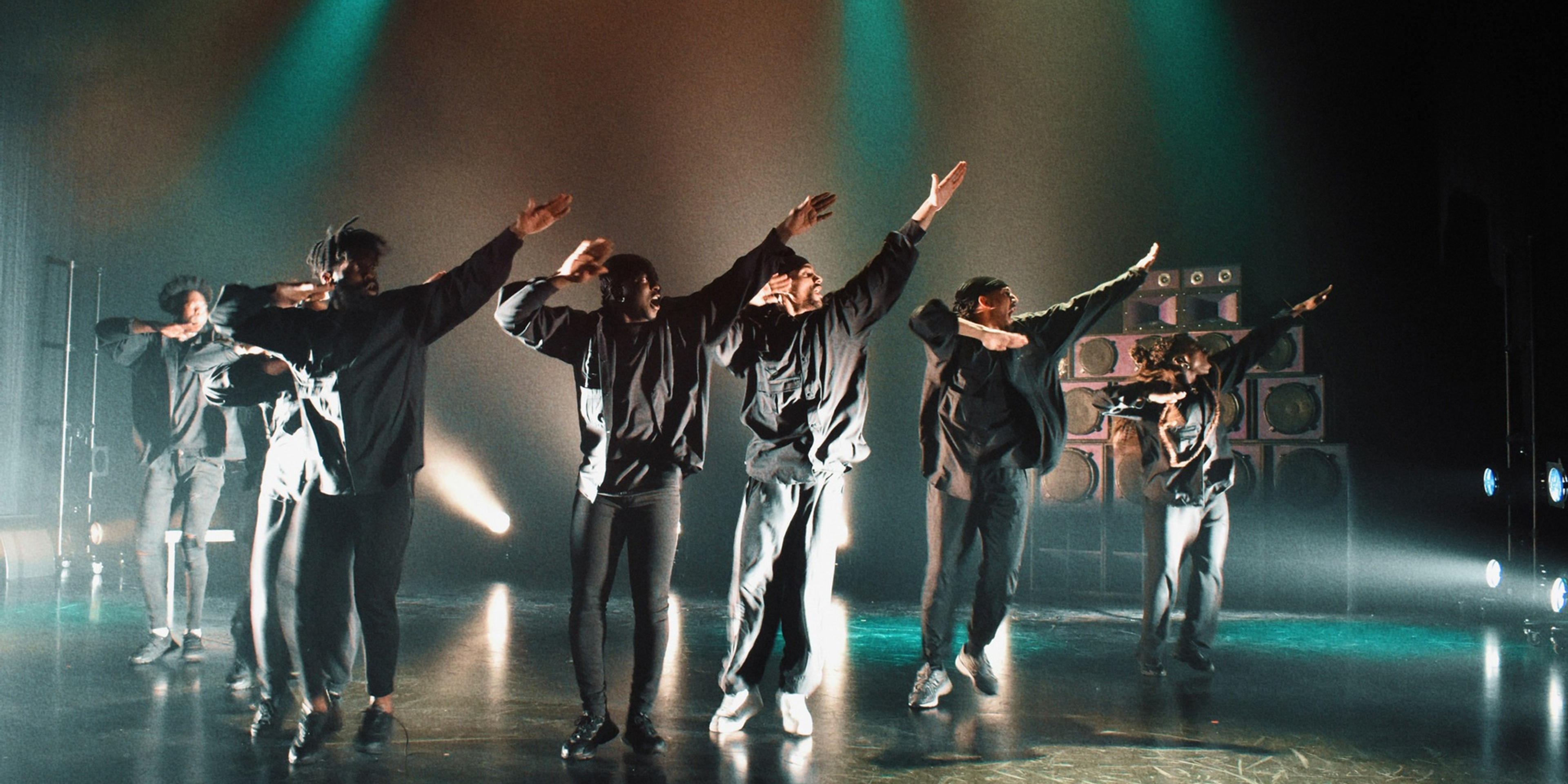 Unruly Gang på scen med armarna i luften under föreställningen