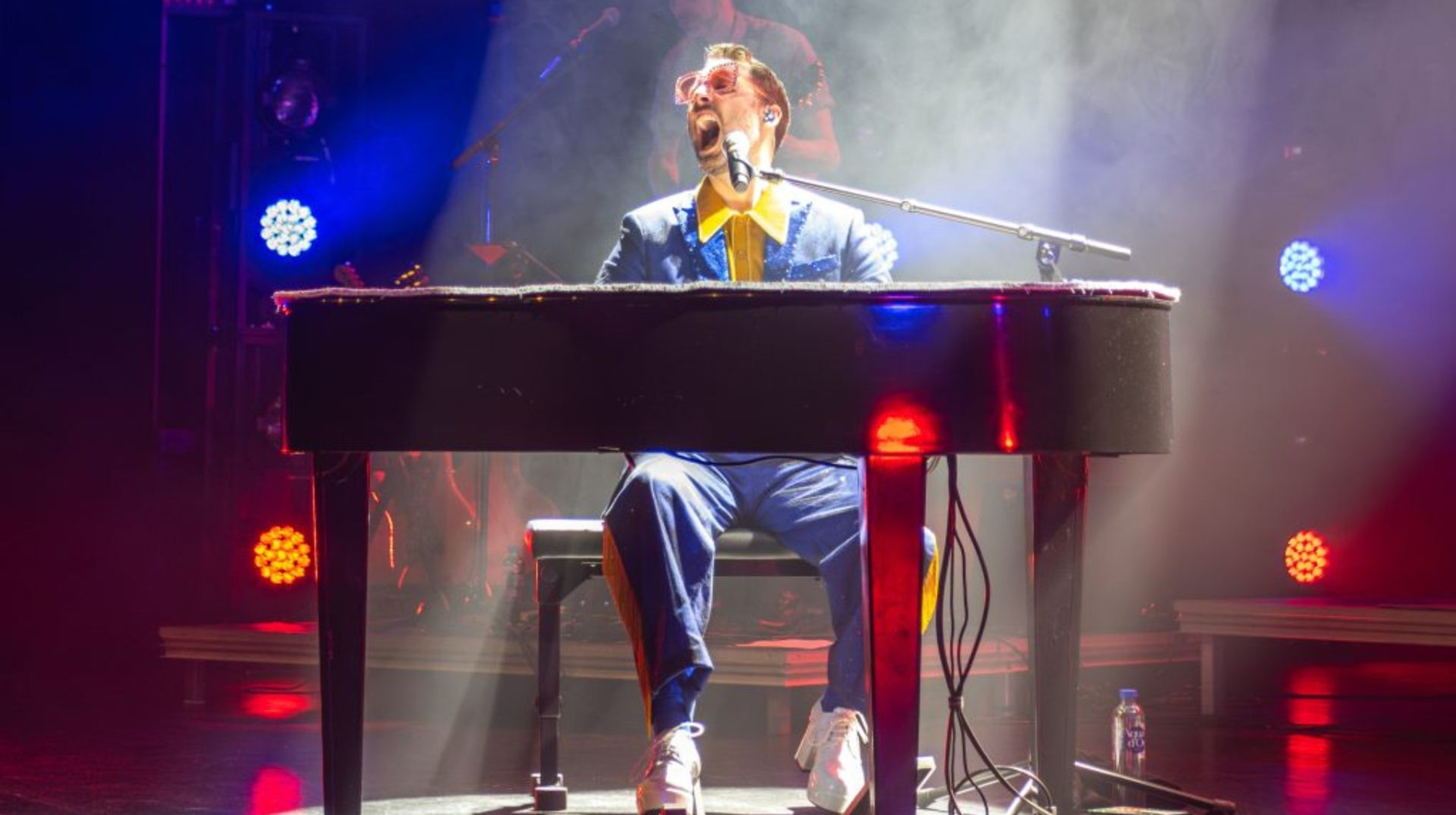  Jonas Gideon som Elton John sitter bakom flygeln och spelar och sjunger.