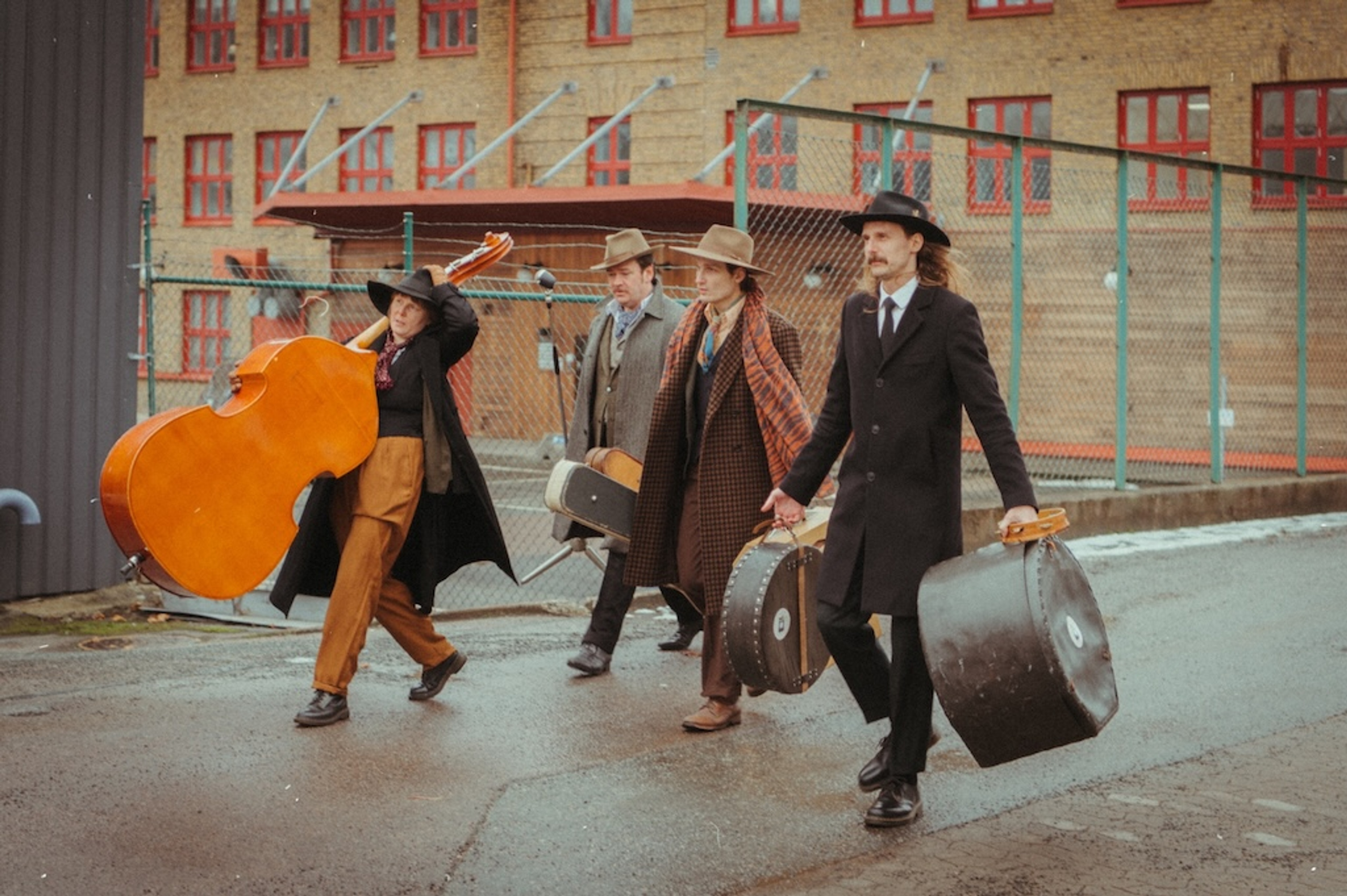 Fyra musiker bärandes på sina instrument. 