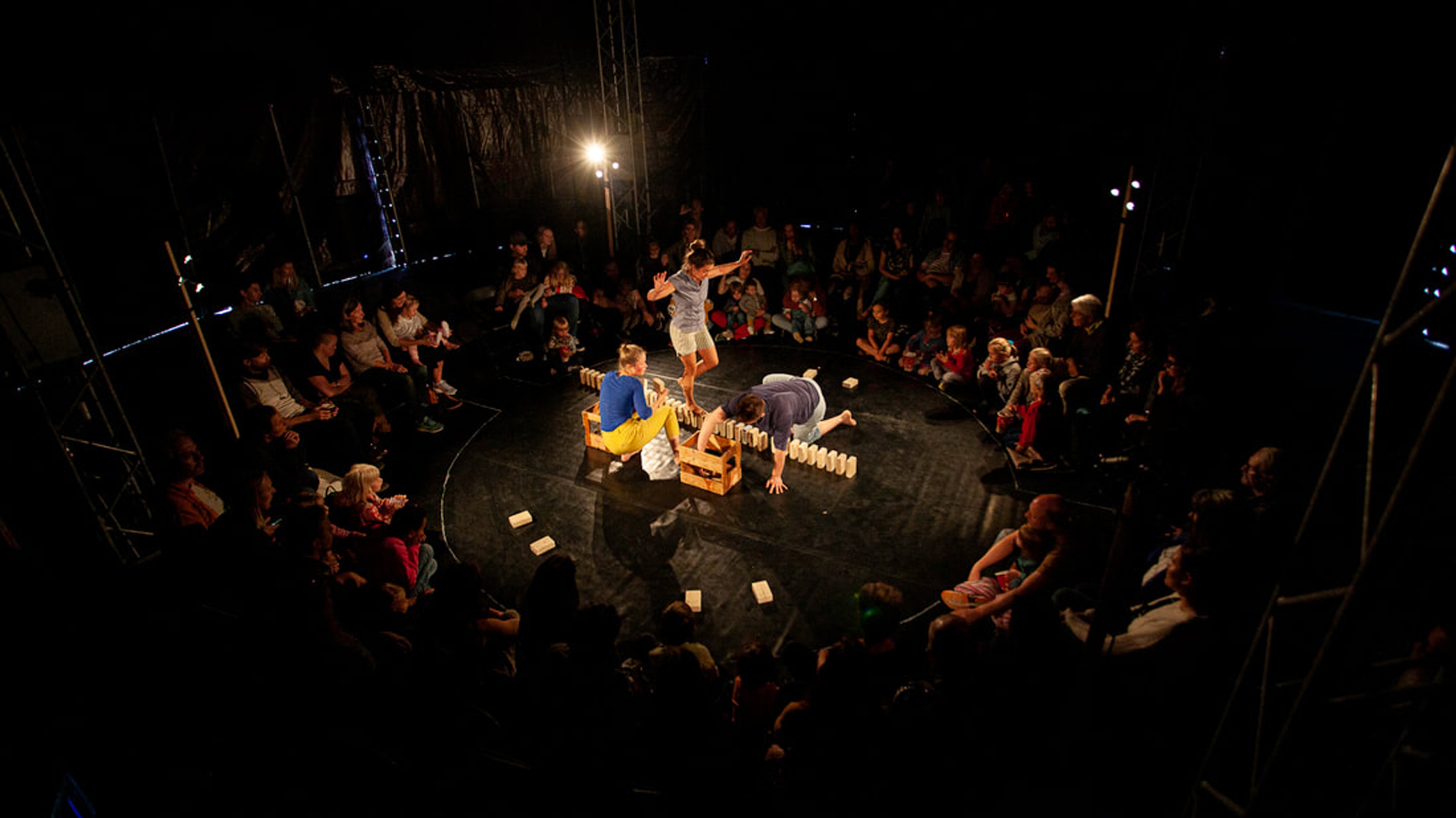 Publik sitter runt cirkusartister.