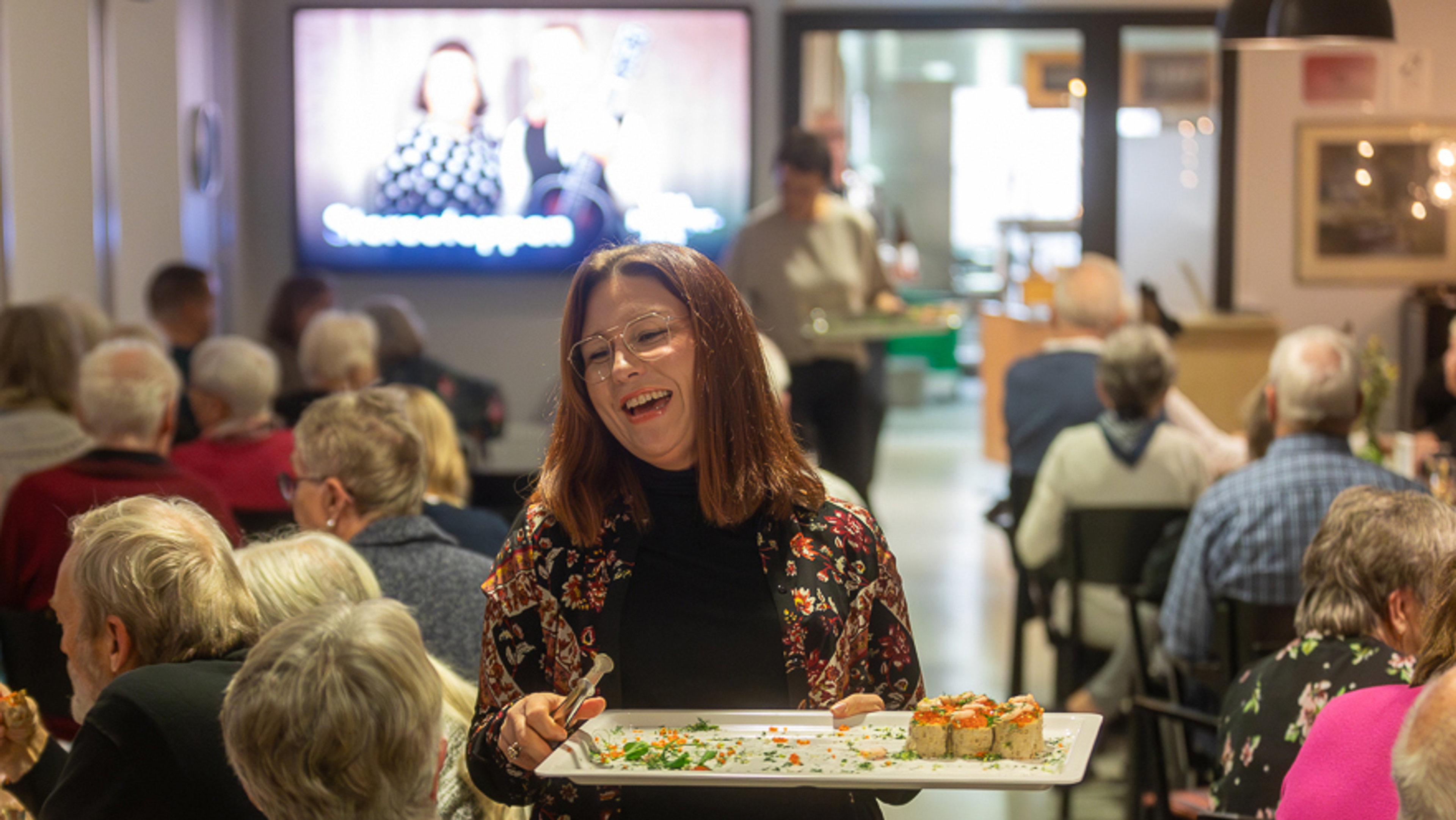 En person delar ut snittar till publiken