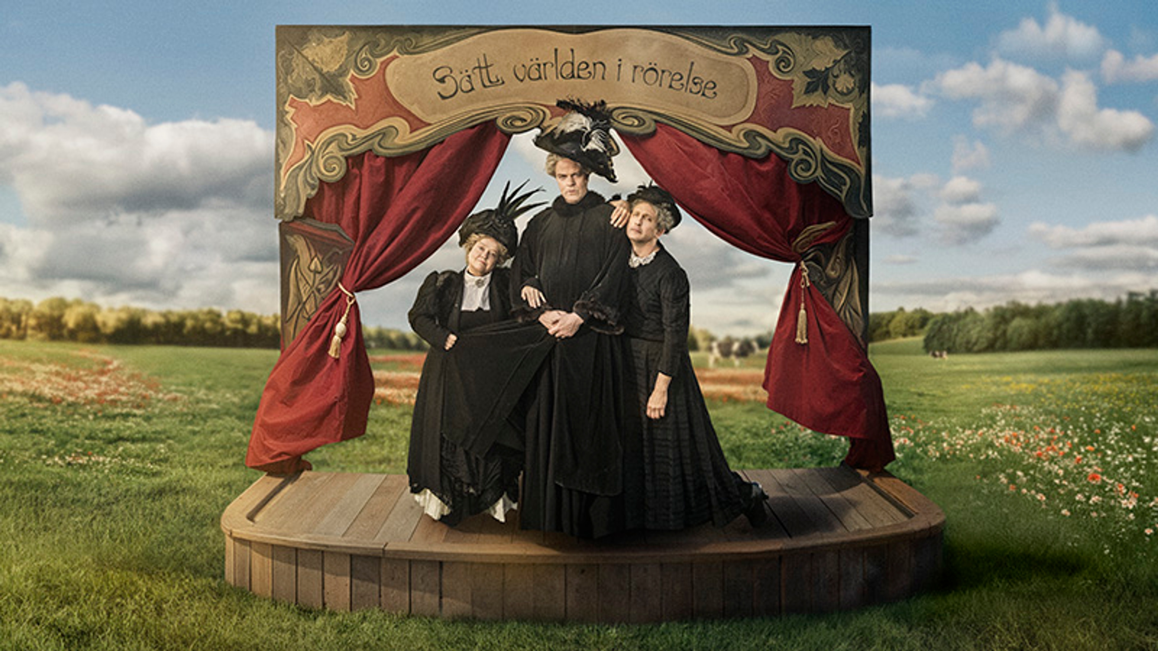 Ensemblen står en scen på en äng.