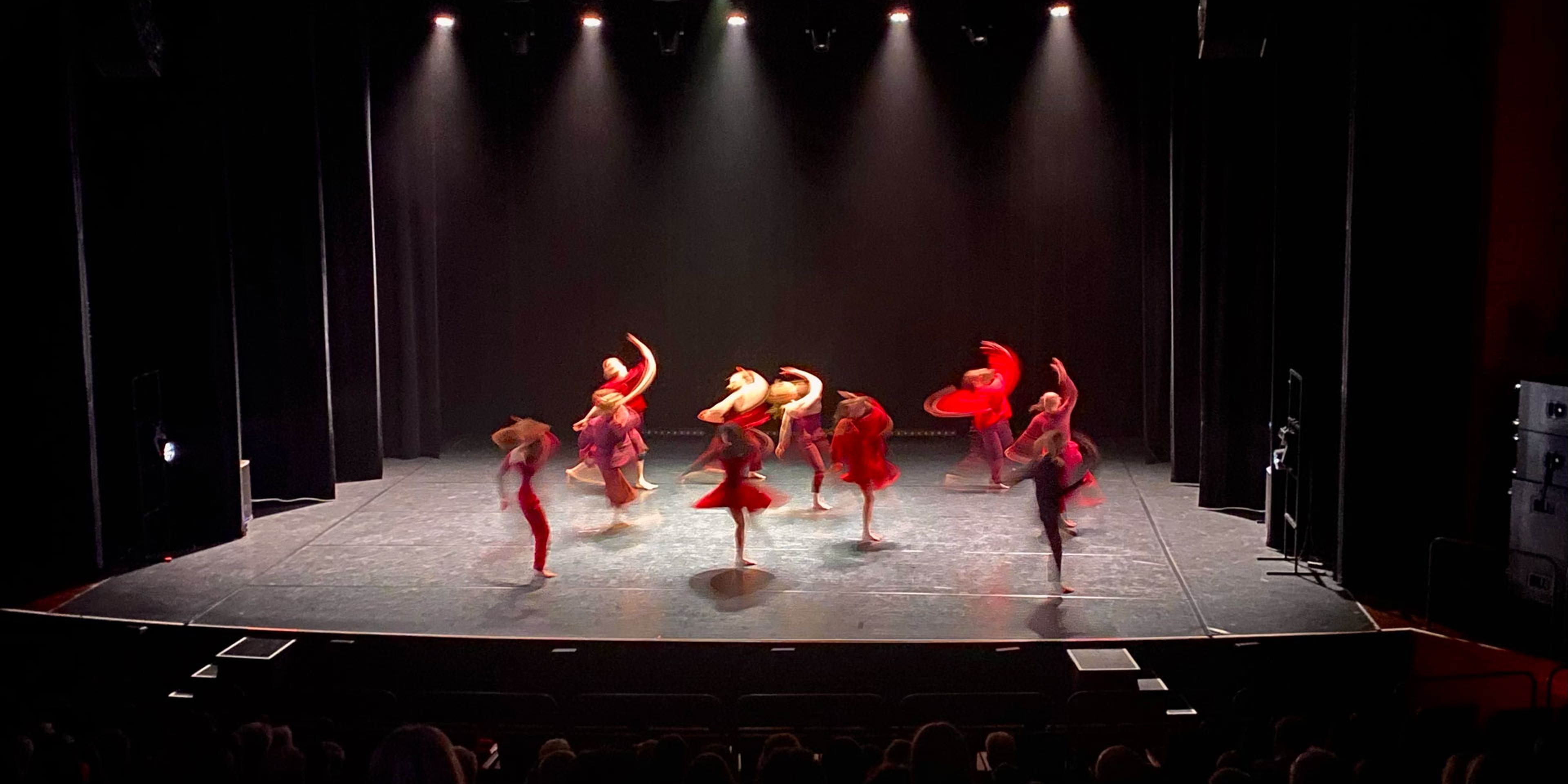 Dansare klädda i rött på scenen