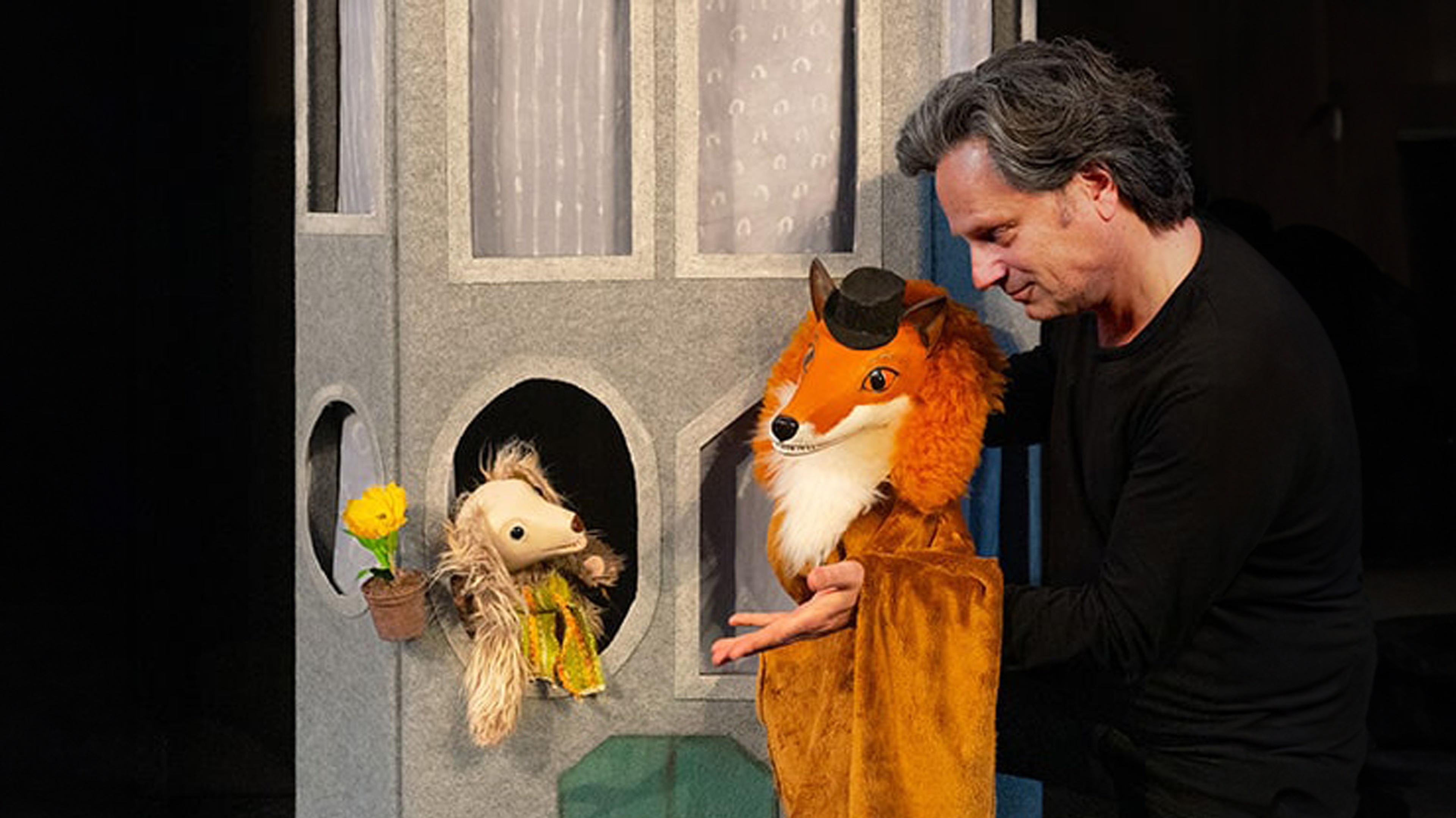 Skådespelaren Mårten Hedman med två handdockor som föreställer en räv och en hund.