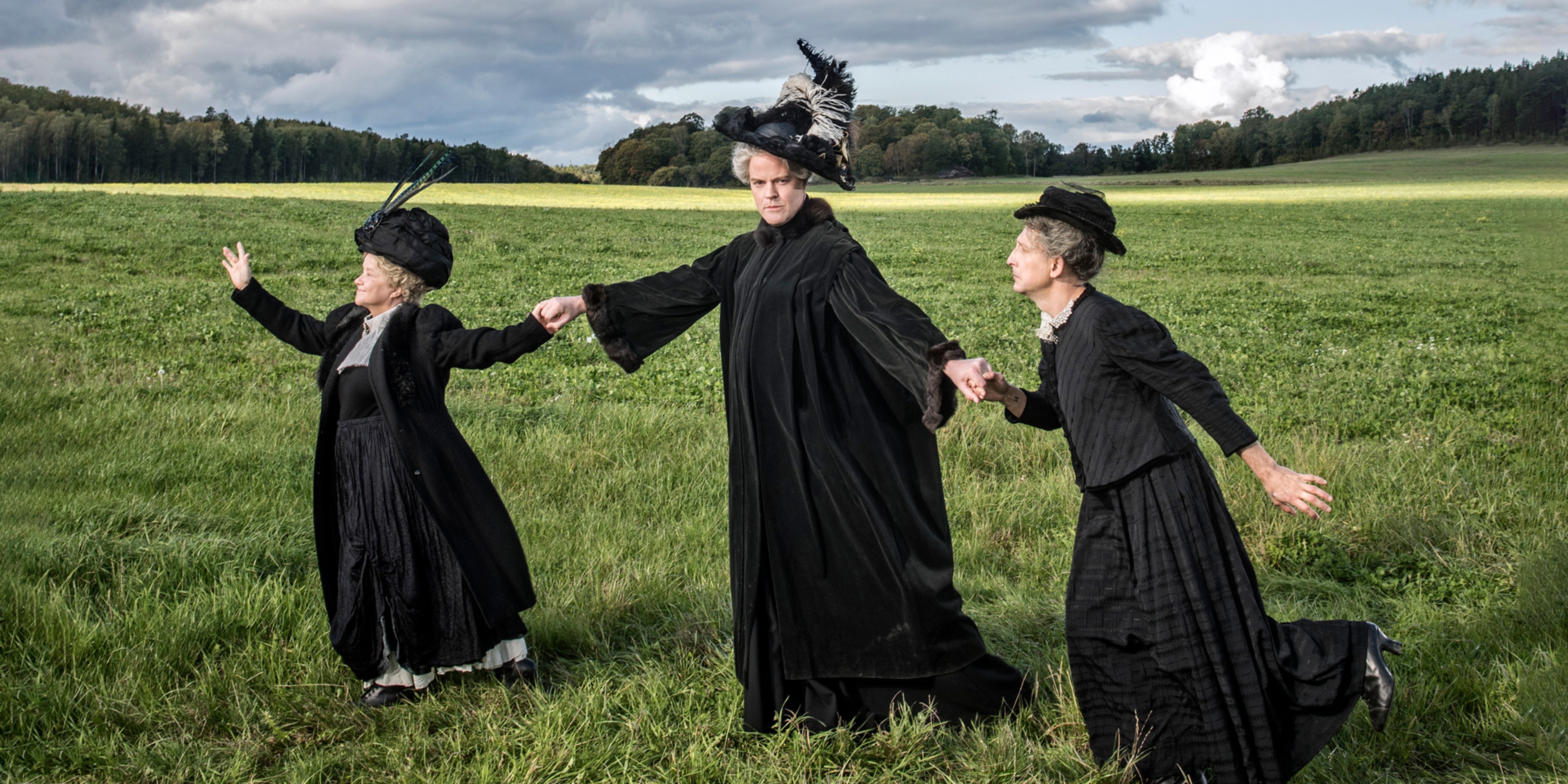 Ensemblen ur Uppdrag Holgersson utklädda till Selma Lagerlöf på en äng.