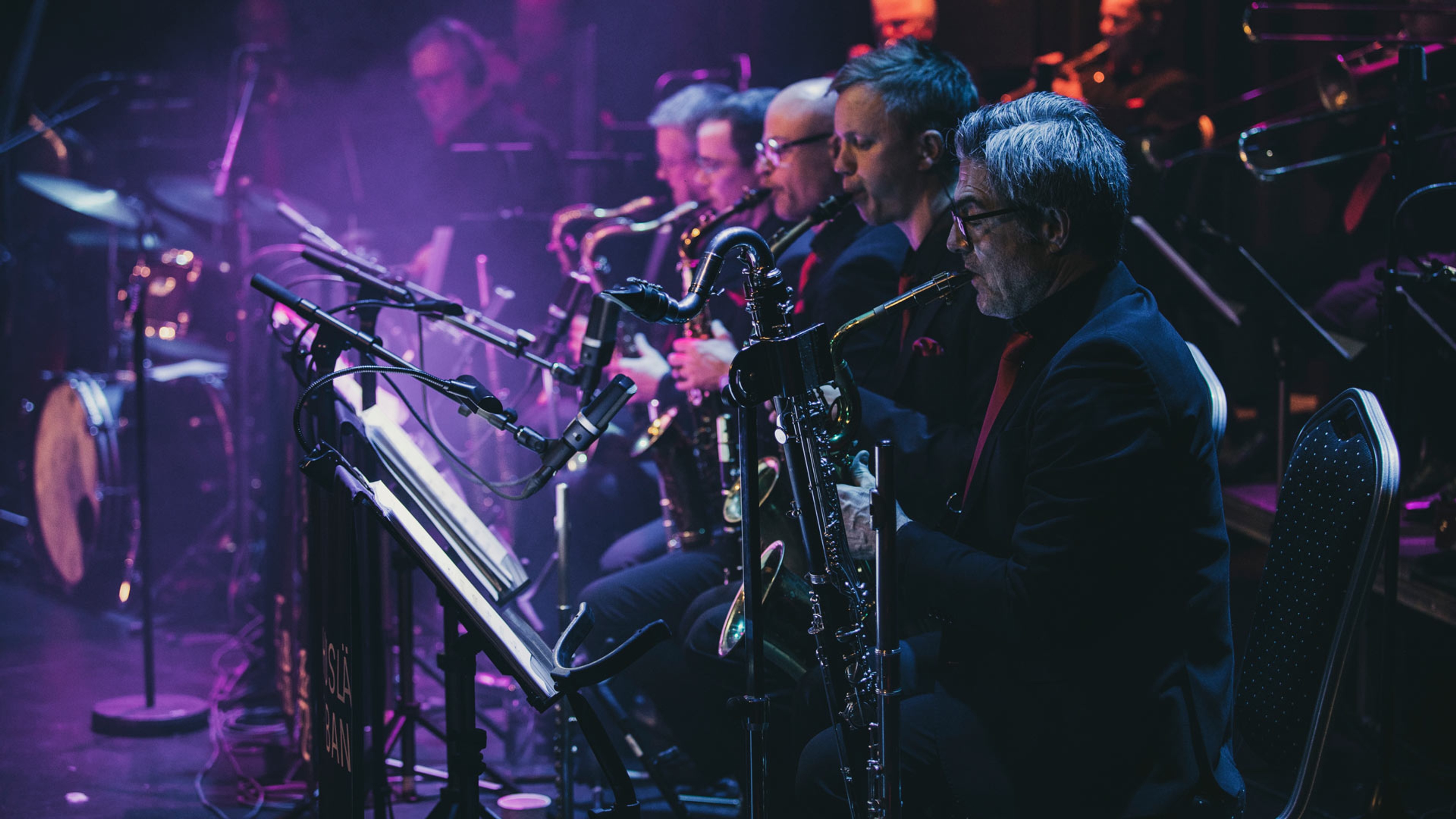 Musikerna i Bohuslän Big Band spelar på scenen. Saxofonsektionen är i fokus.