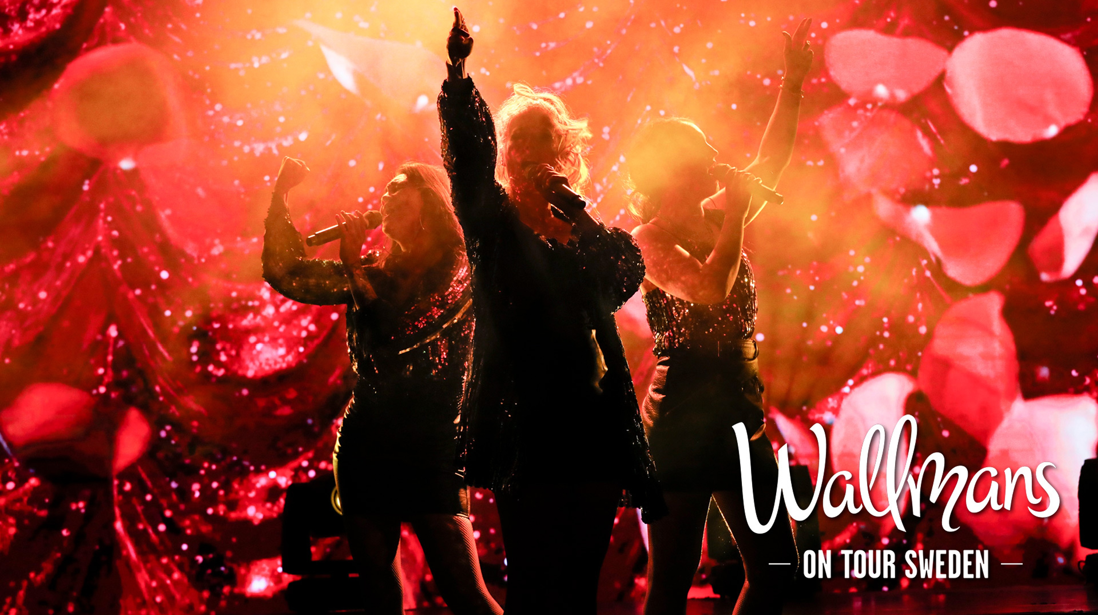 Delar av ensemblen ur Wallmans står och sjunger framför en röd och glittrande bakgrund. Text: Wallmans On Tour Sweden