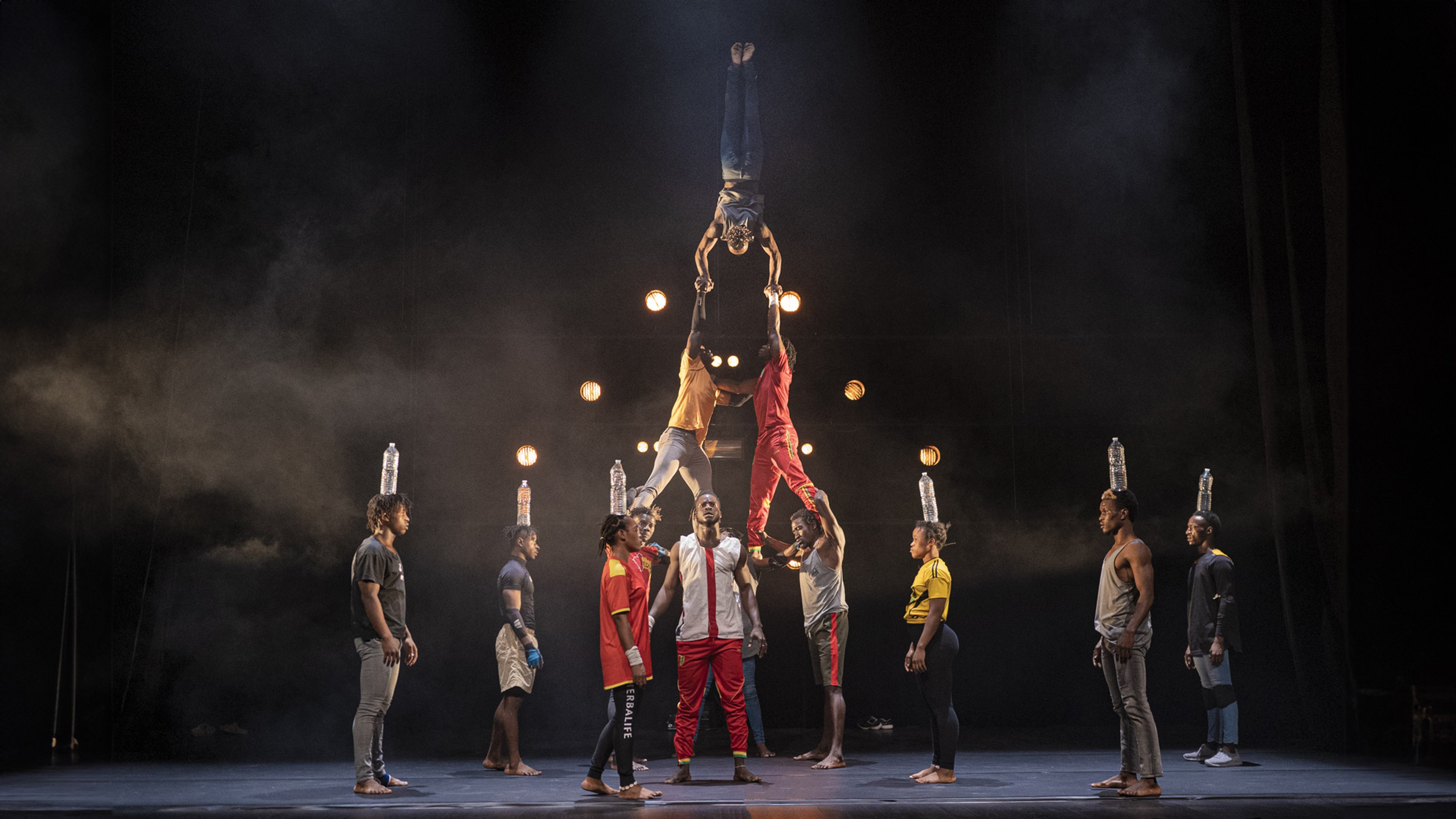 Flera dansare på scen skapar mänsklig pyramid.