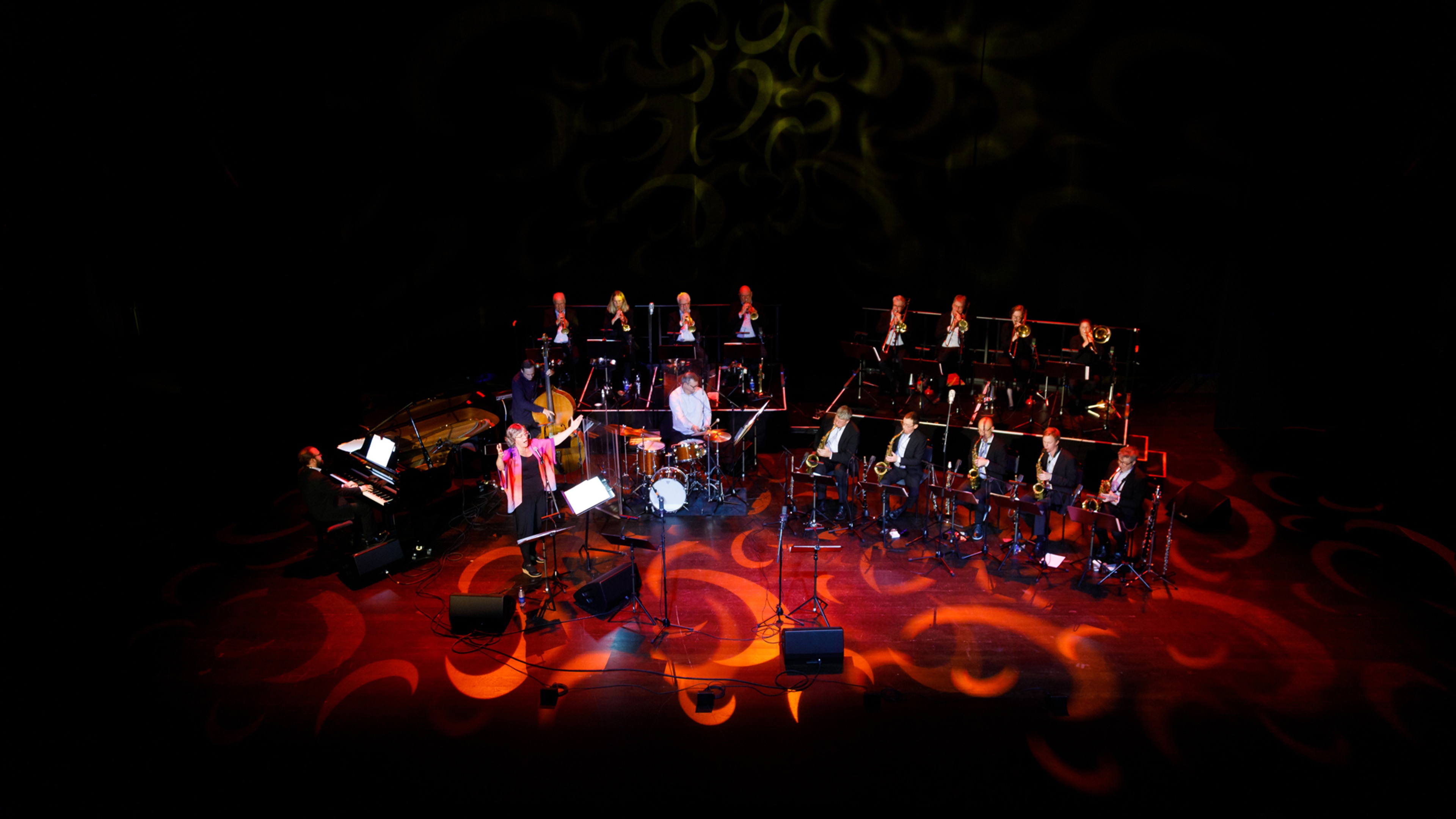 Storband på scen med solist och rött scenljus.