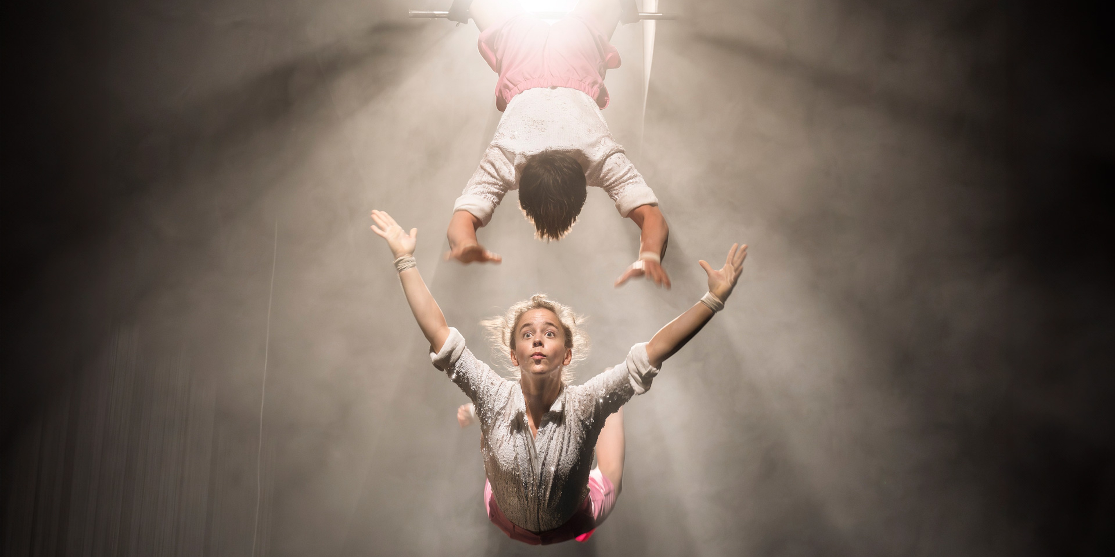 Två akrobater svingar sig i luften