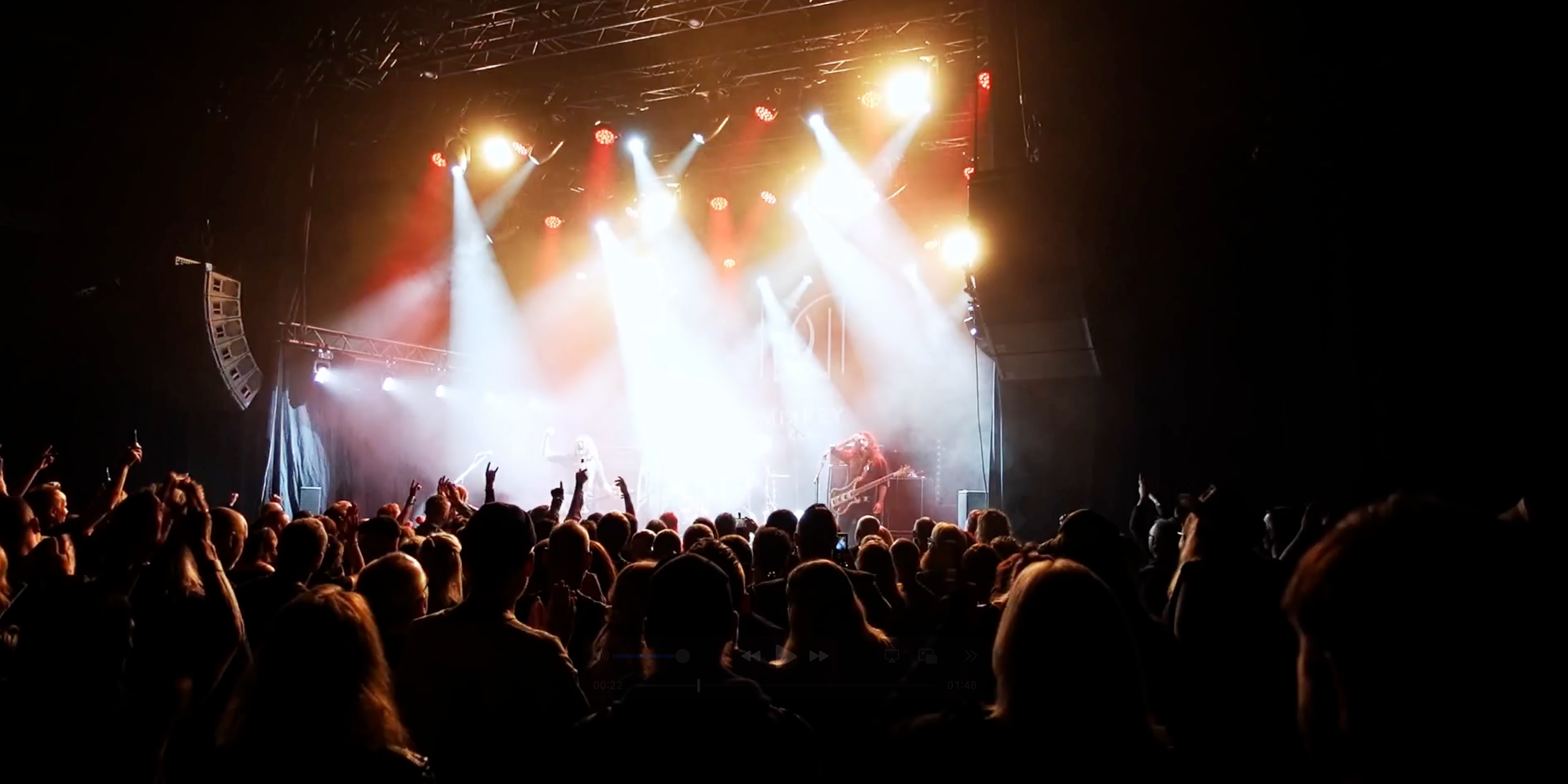 Rockkonsert med stående publik och mycket scenljus.