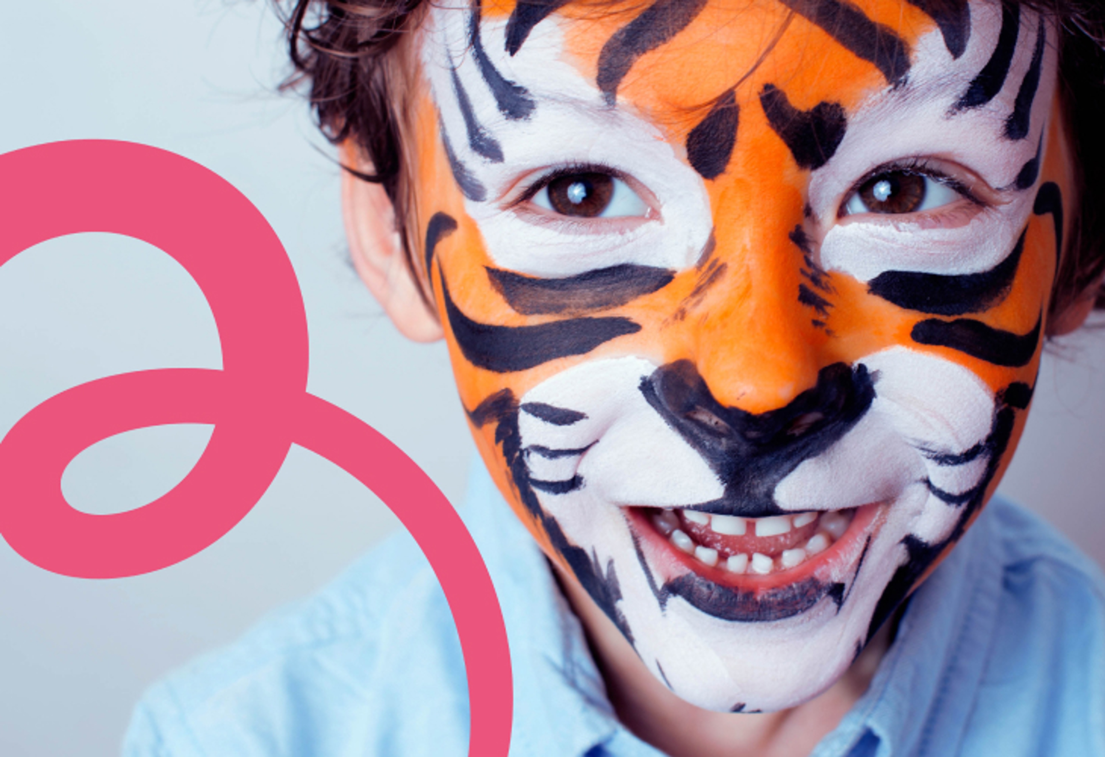 Glad pojke med ansiktsmålning som en tiger.