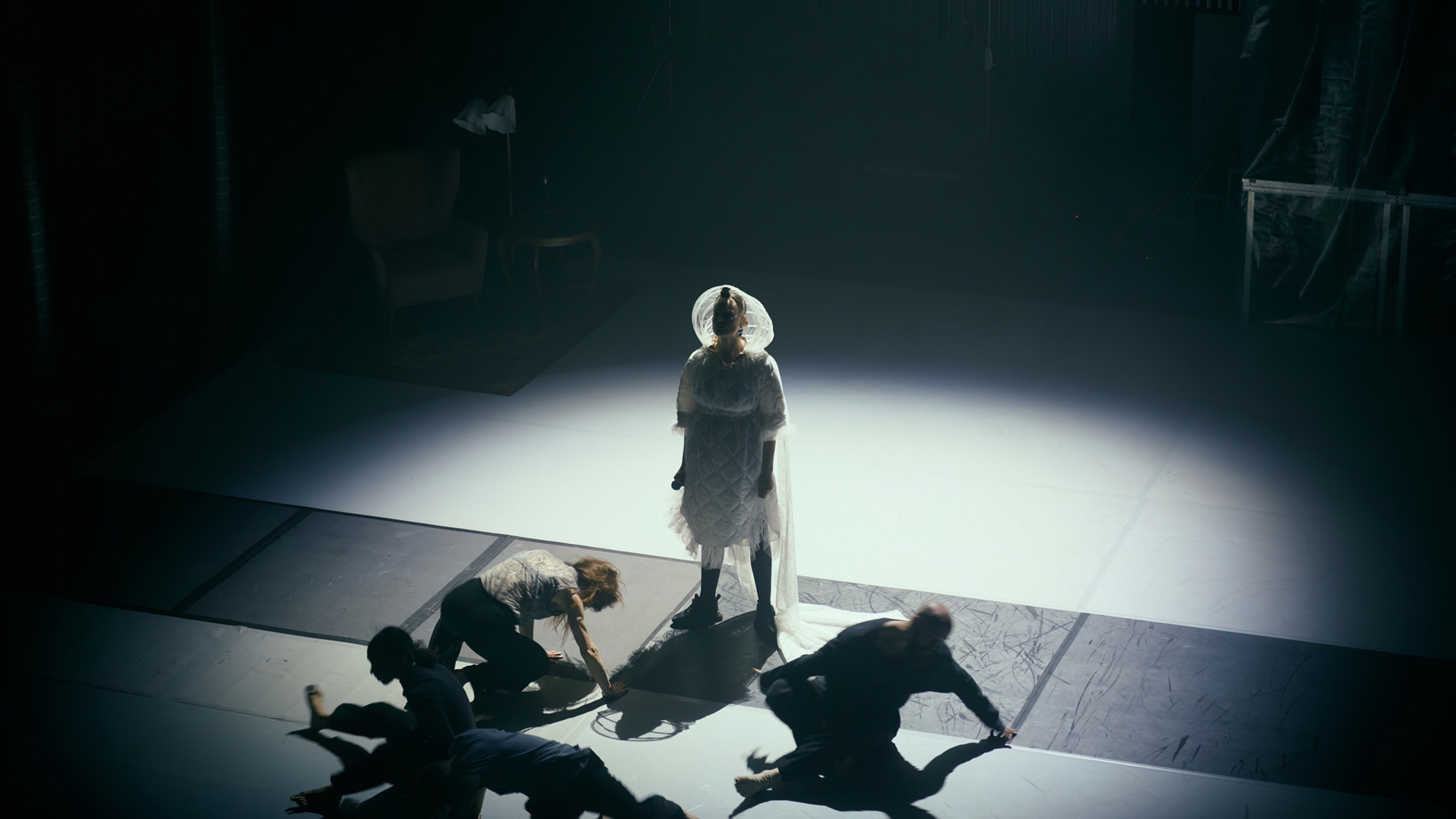 Dansare rör sig på golvet framför sångare iklädd vitt.