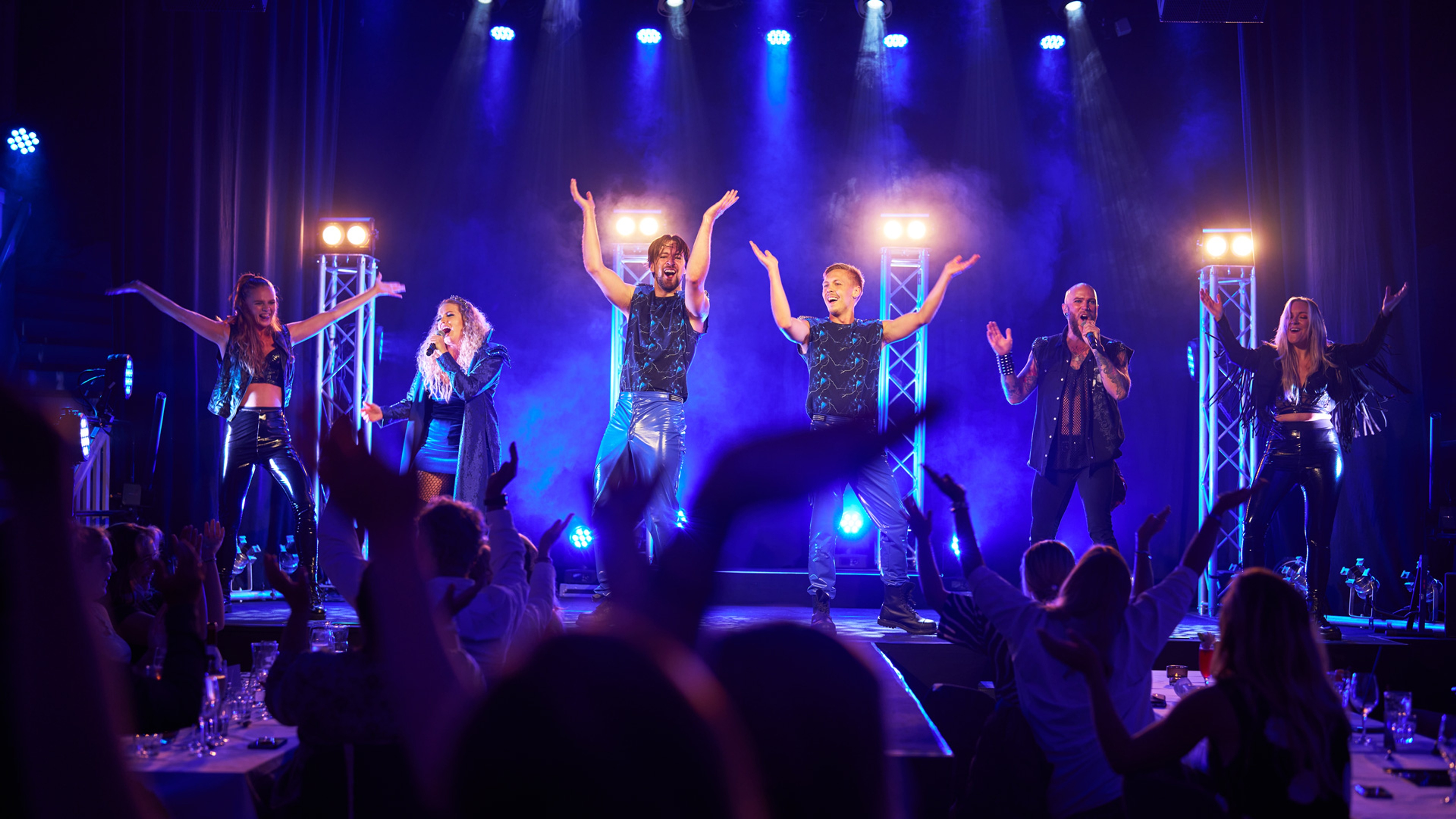 Dansande sångare på scen framför publik.