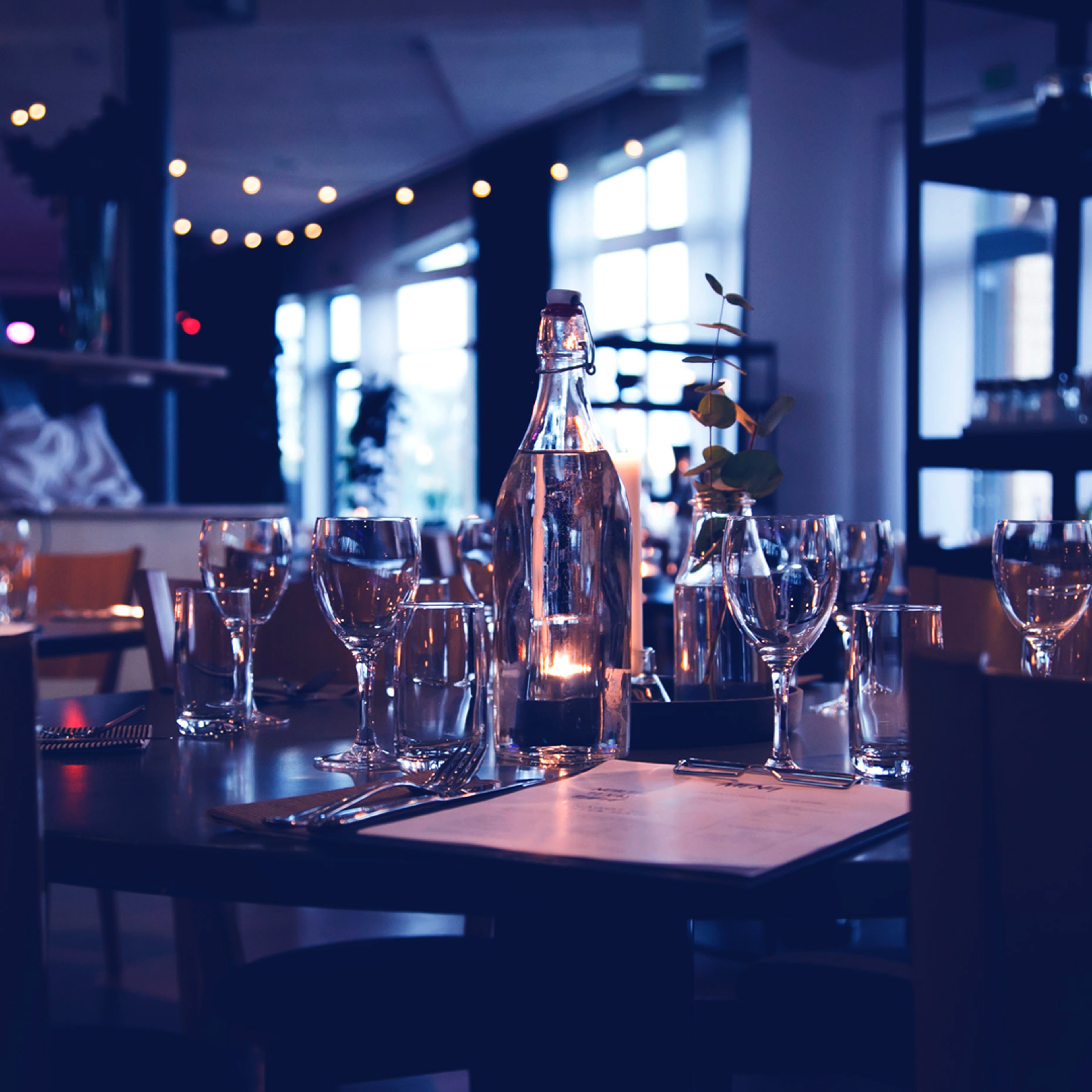 Ett dukat bord med vinglas och menyer.