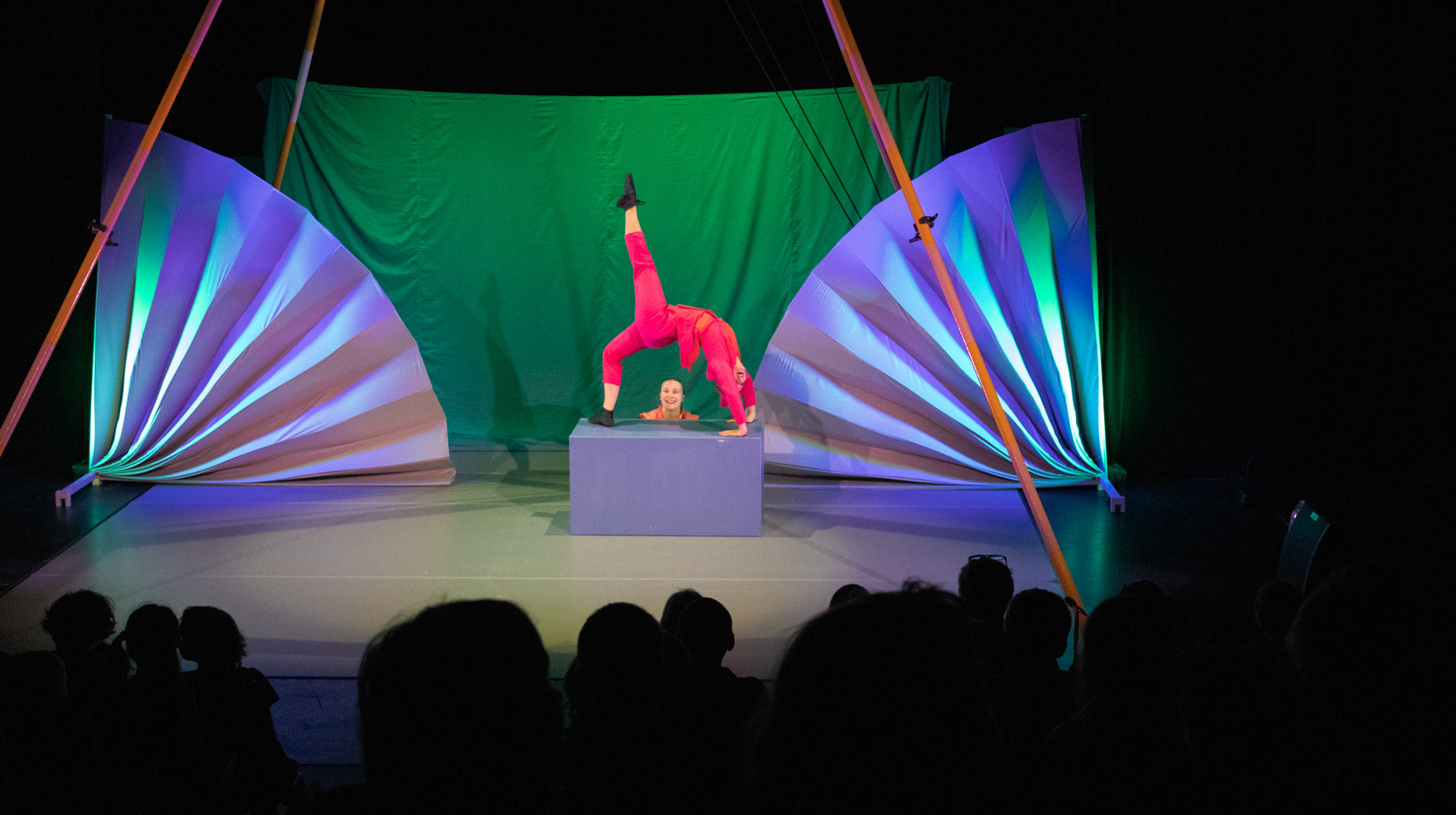 Akrobat på scen framför publik.