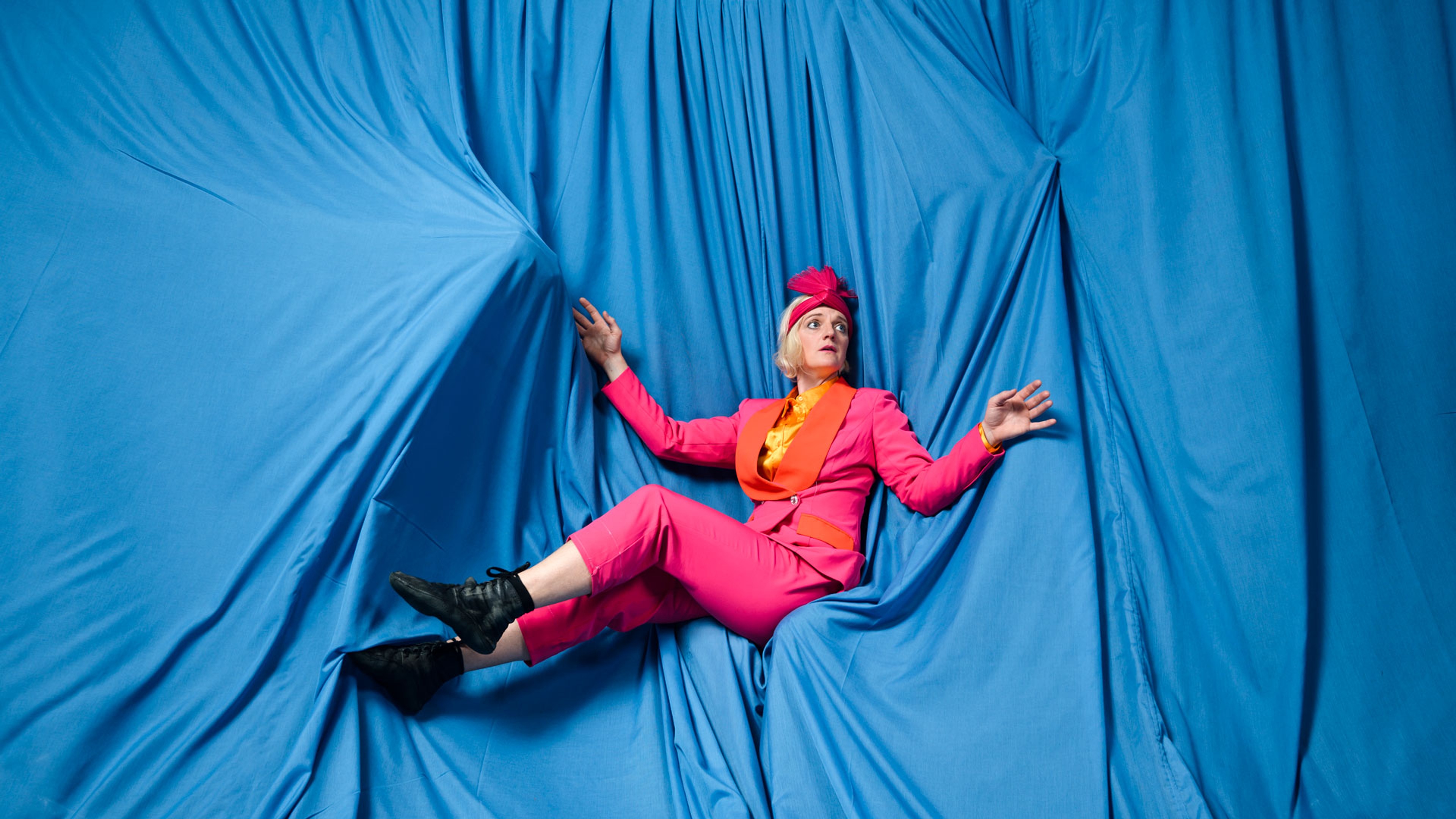 En av de medverkande ligger ned bland blå tyger