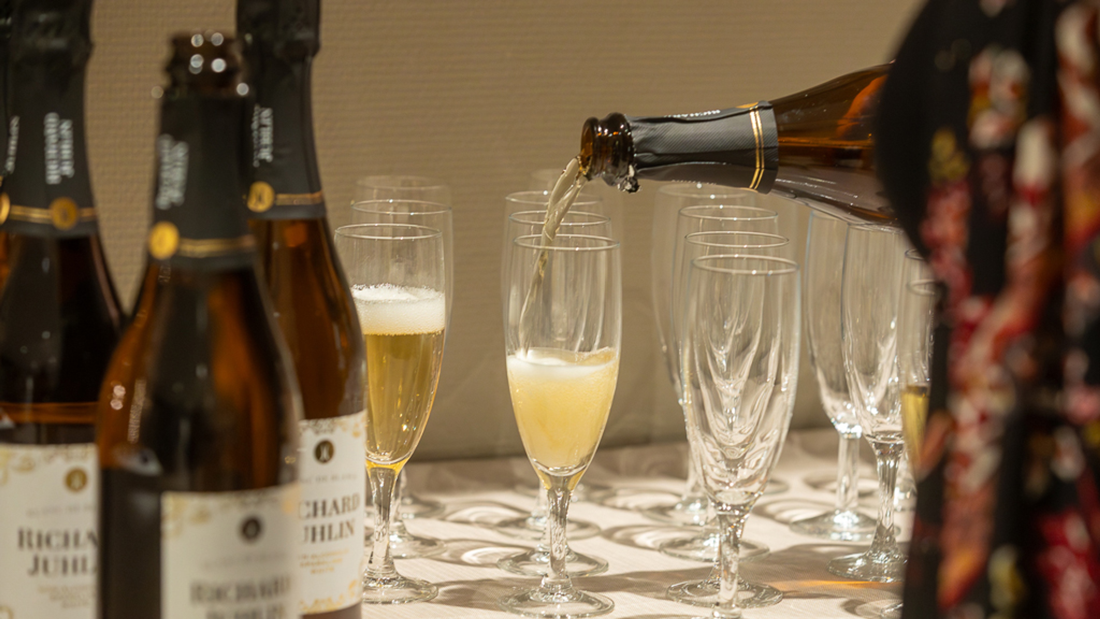 Dryck serveras i glas med flaskor i förgrunden
