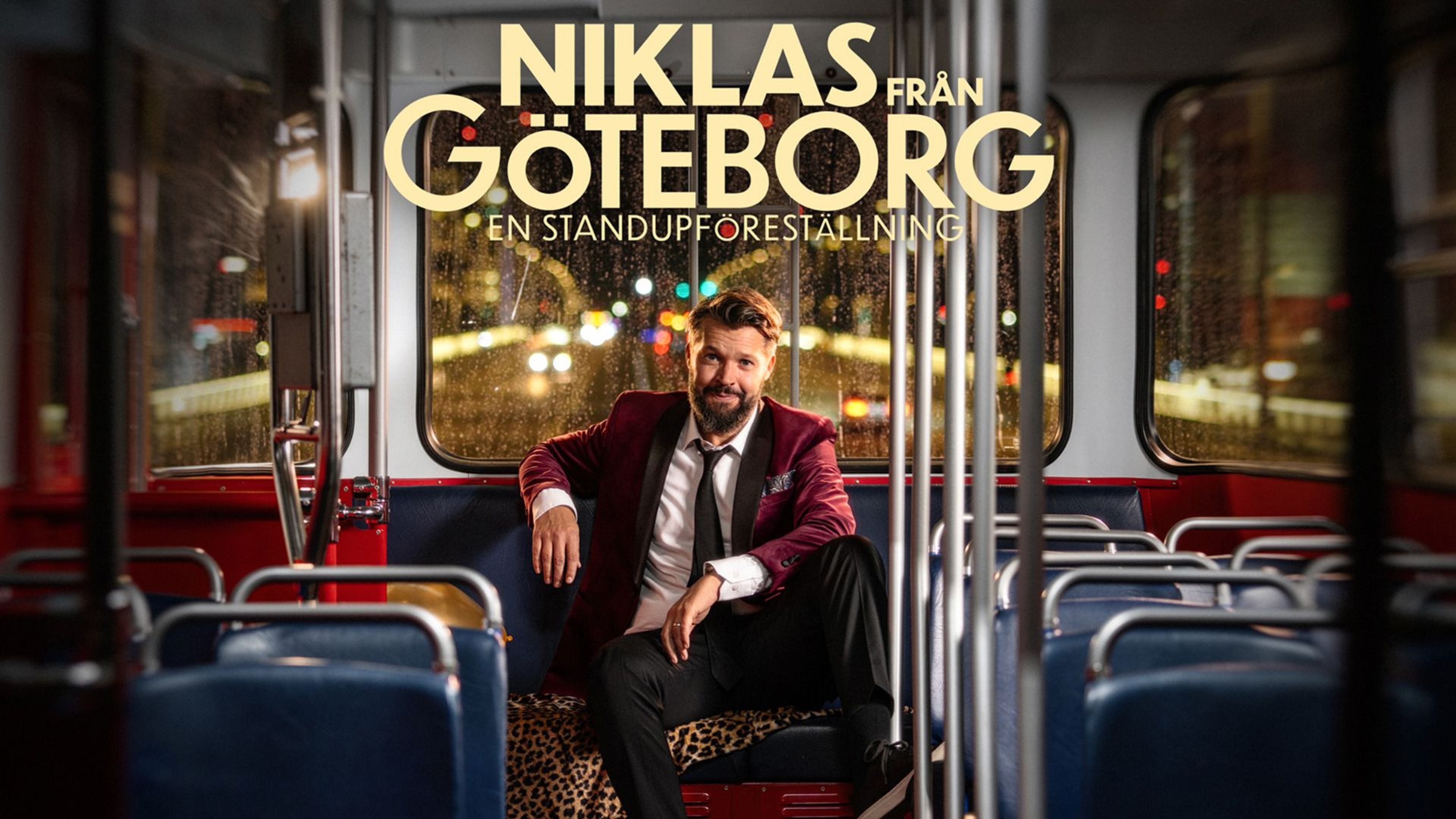 Niklas sitter i ett säte längst bak i en spårvagn. Det är kväll, regn på fönsterrutorna och utanför syns gatljus.
