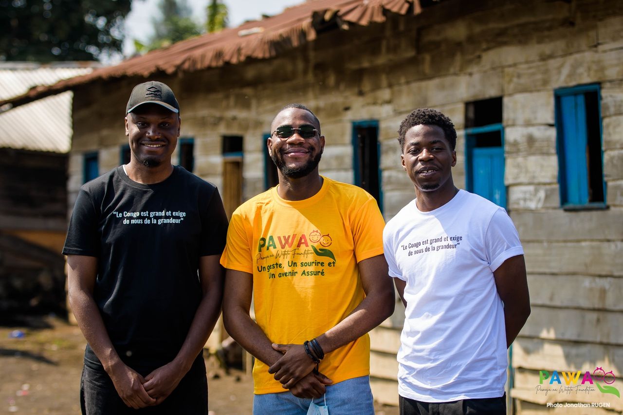 Trois bénévoles de La Force d'Aimer et PAWA devant une école de Goma
