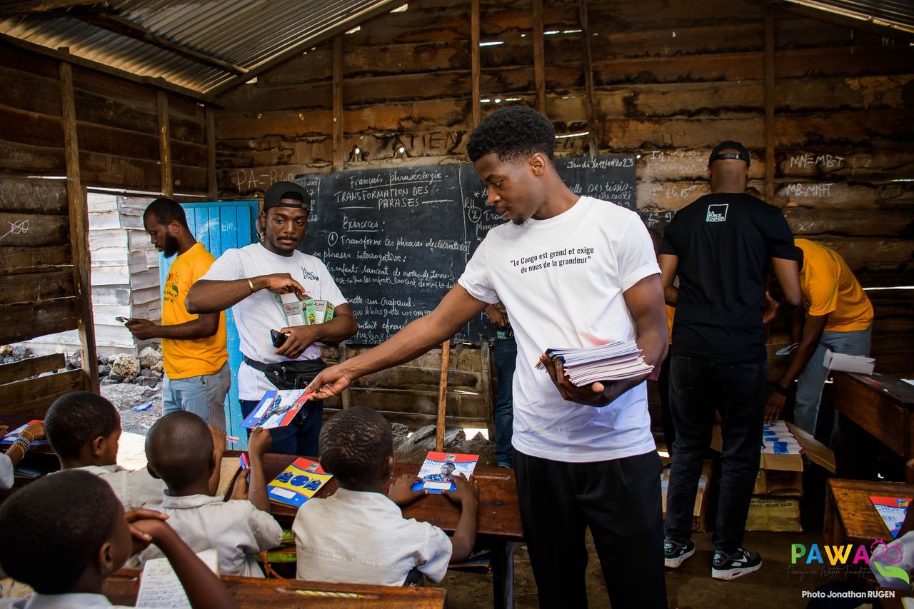 Remise de cahiers aux écoliers pendant une distribution de kits scolaires à Goma