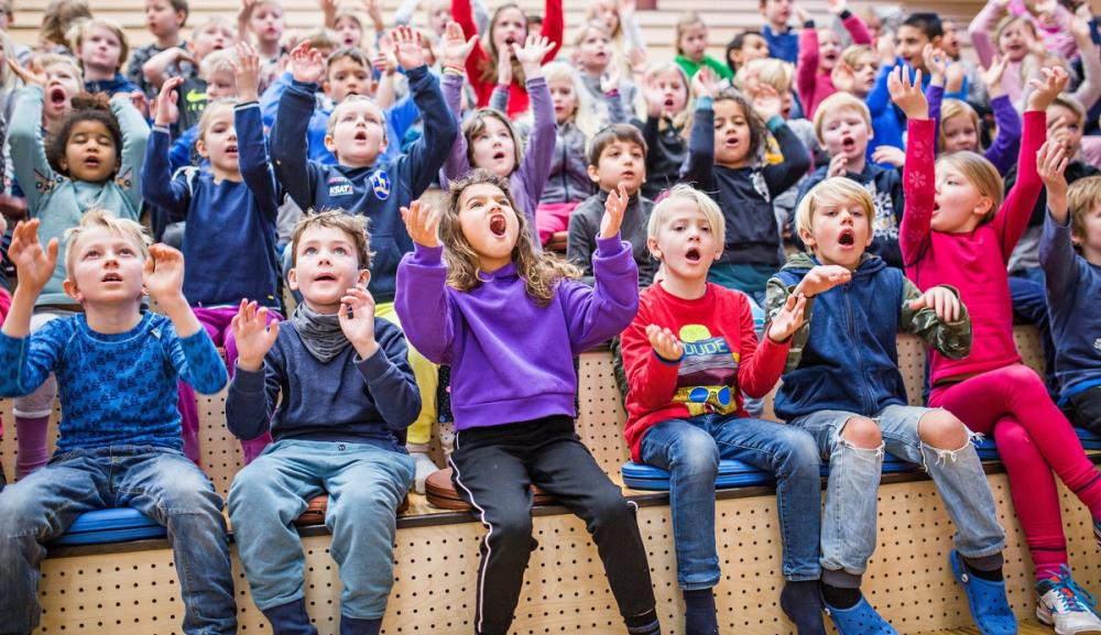 Stor barnegruppe som synger