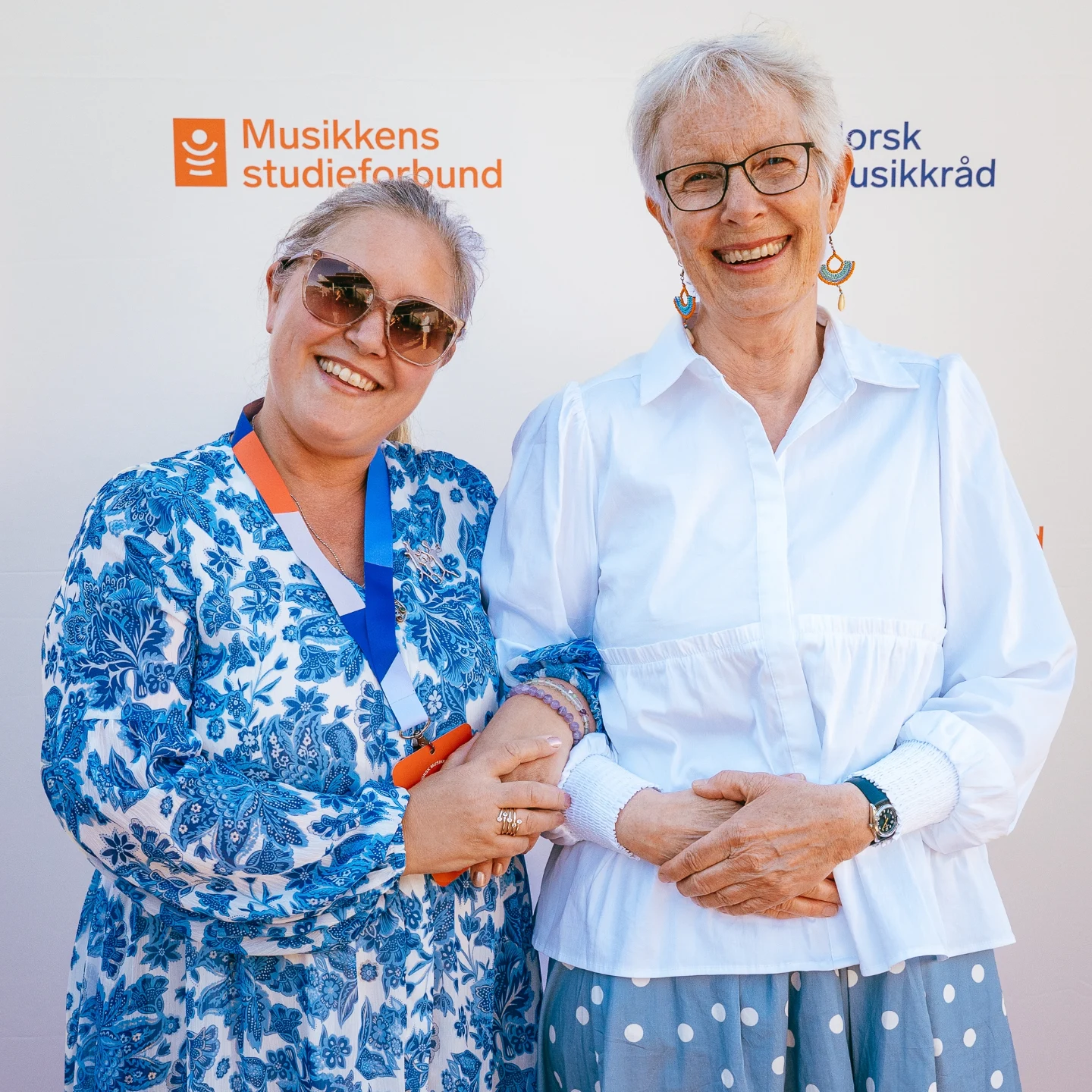 Bilde av styreleder og medarbeider festkledde og glade.