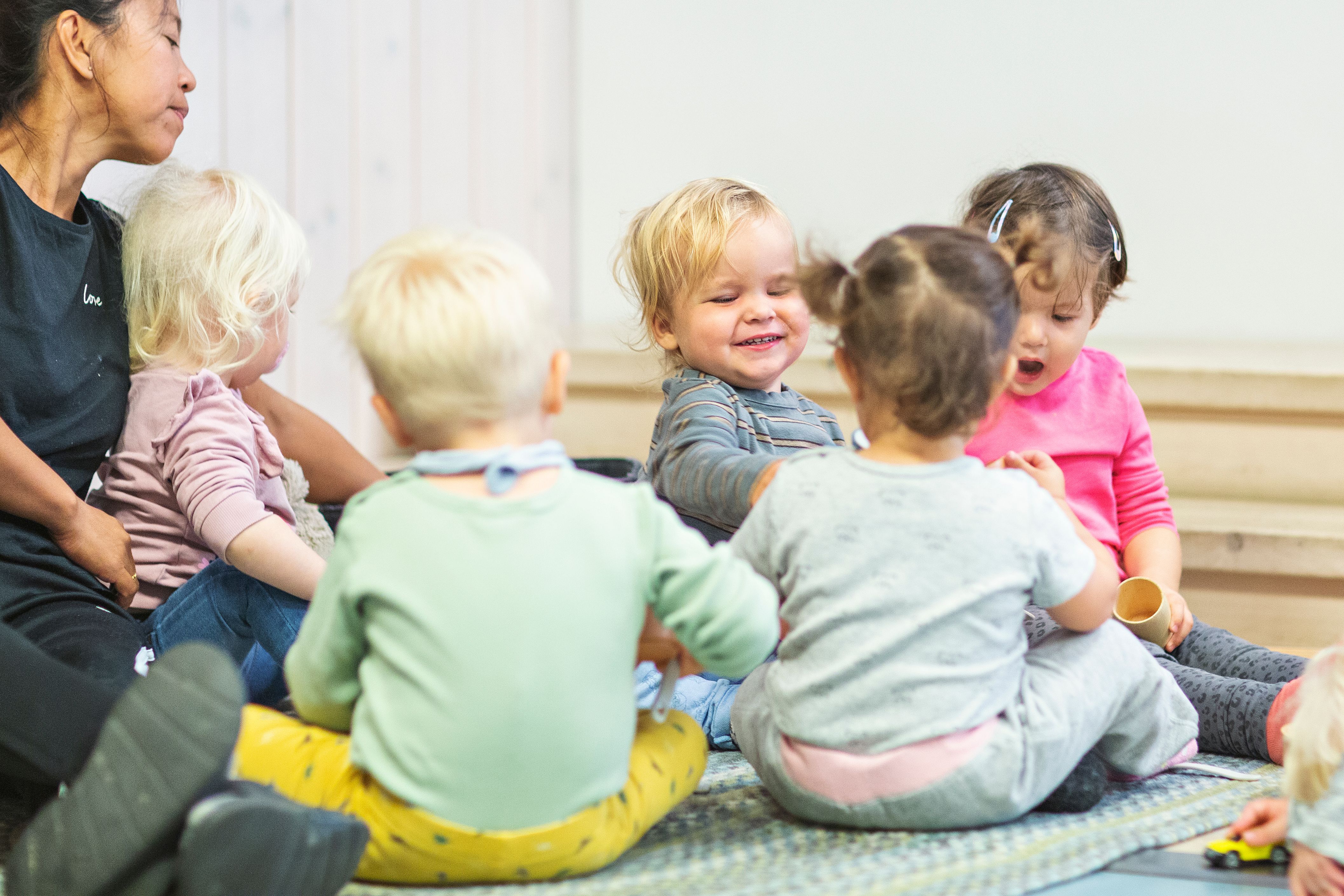 Flere babyer ligger på gulvet under shiffongsjal.