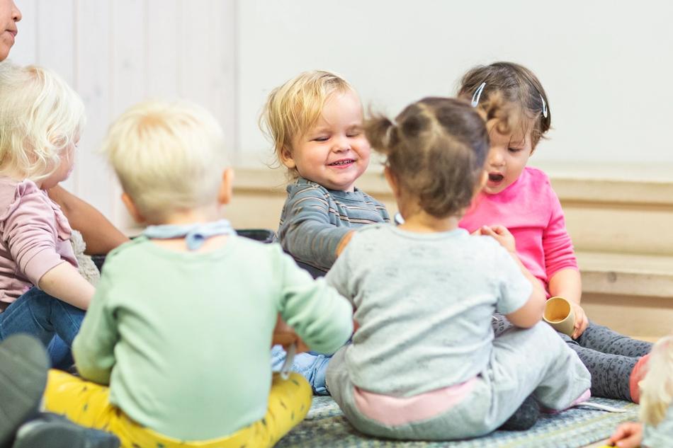 Flere babyer ligger på gulvet under shiffongsjal.