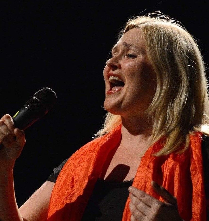 Kursleder Sigrid Randers Pehrson synger med mikrofon.