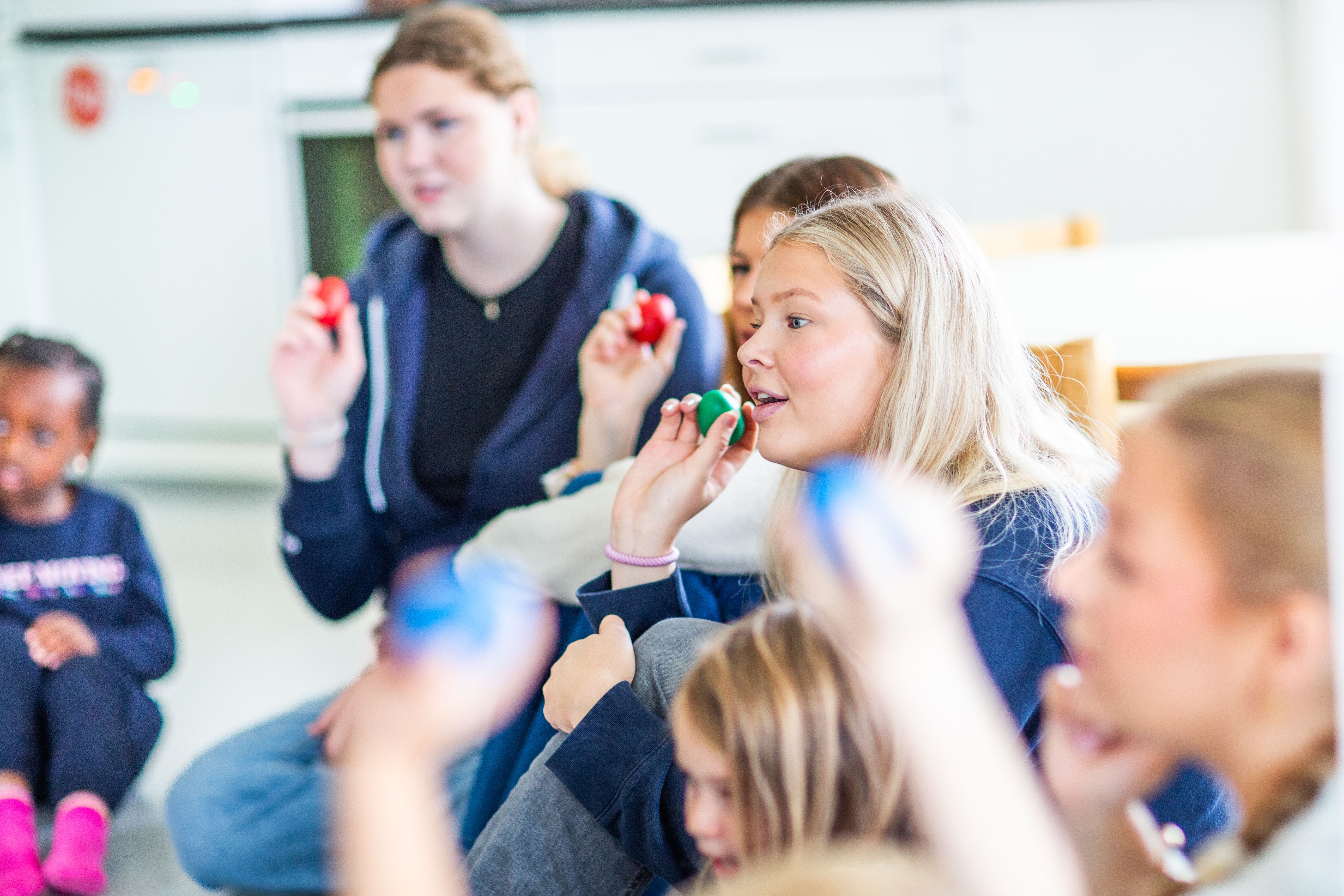 Bilde av vgs-elever som synger sammen med barn