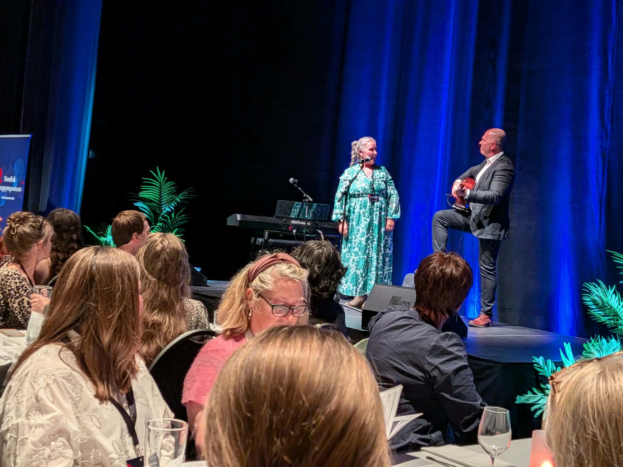 BIlde av en dame og en mann på en scene. 