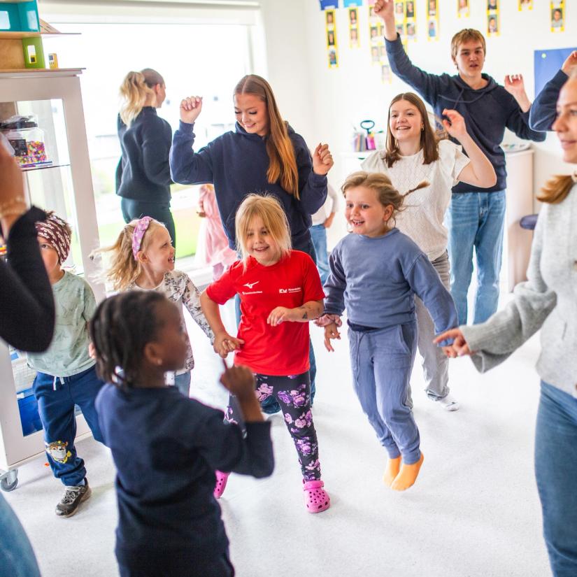 Vgs-elever og barn synger og danser sammen. Foto: Krafttak for sang