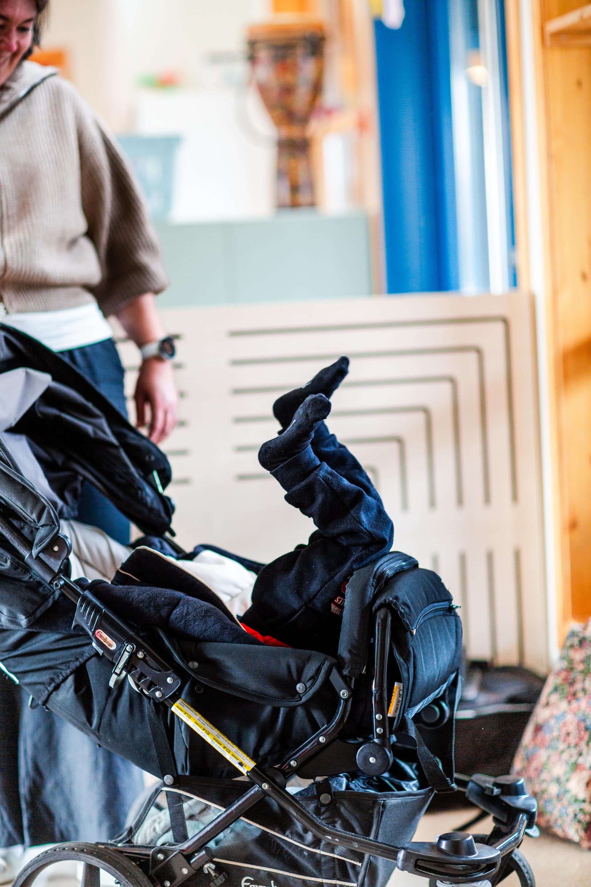 Barn ligg opp ned i barnevogna si.