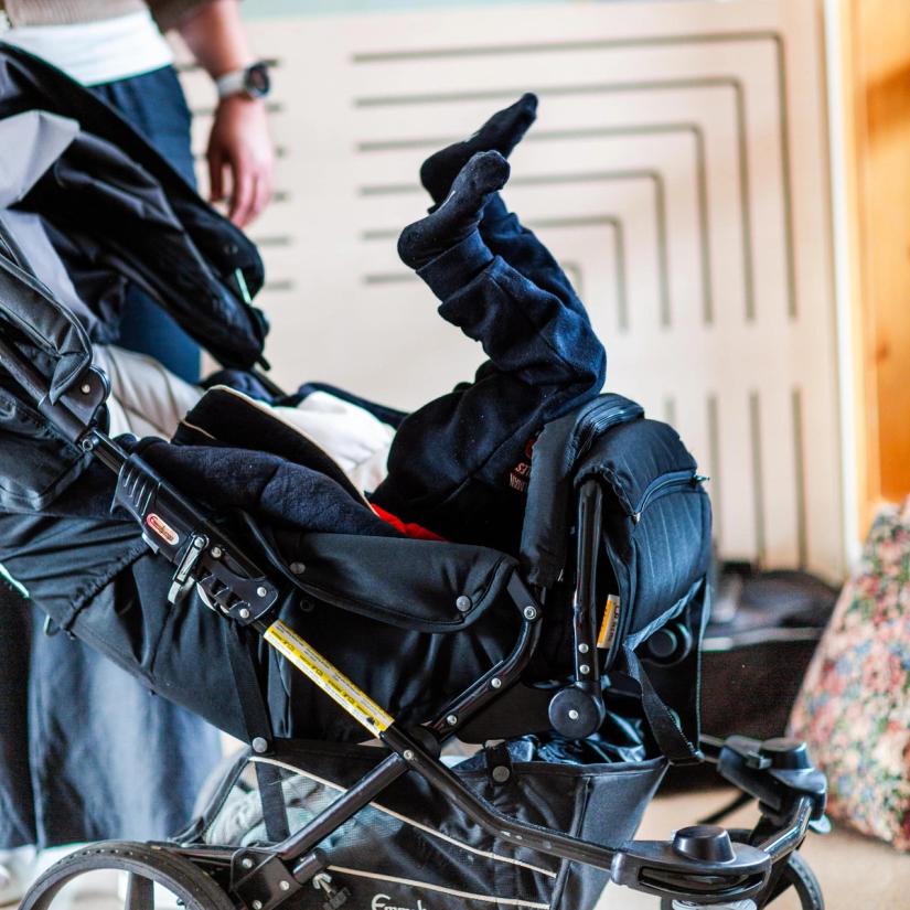 Barn ligg opp ned i barnevogna si.