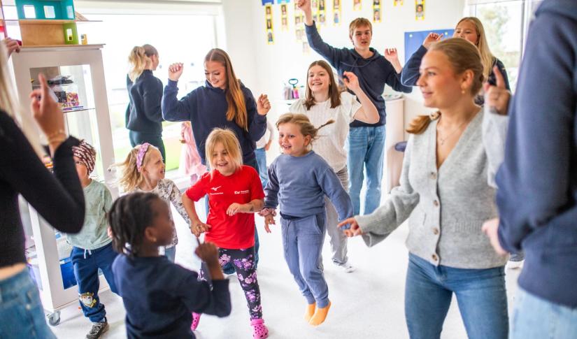 Vgs-elever og barnehagebarn danser og synger sammen. Foto: Krafttak for sang