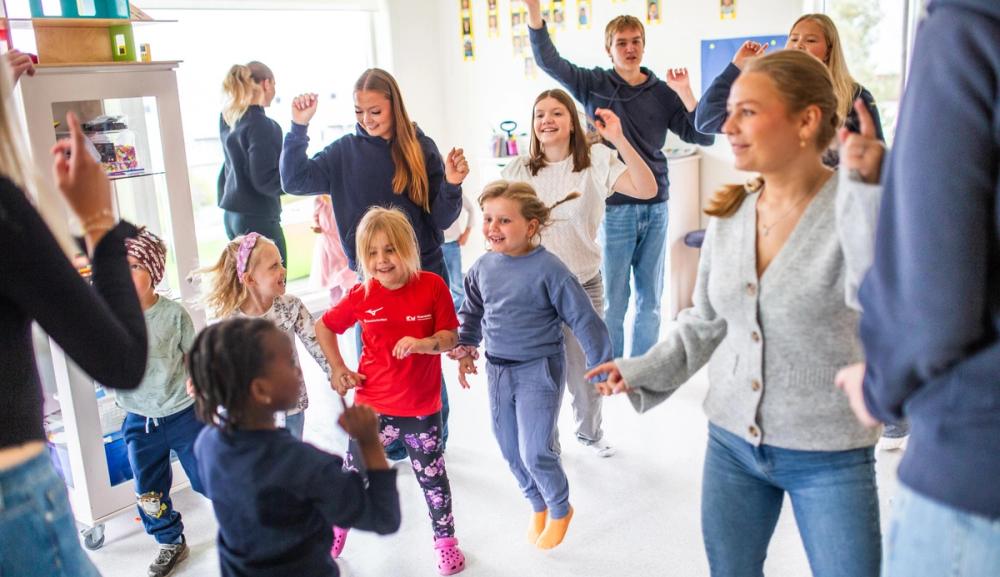 Barn og vgs-elever danser sammen. Foto: Krafttak for sang
