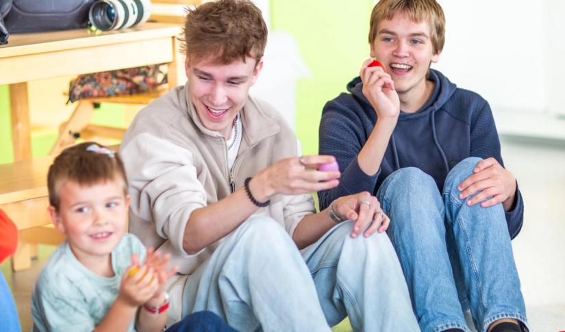 To videregående elever spiller rasleegg sammen med barn. Foto: Krafttak for sang