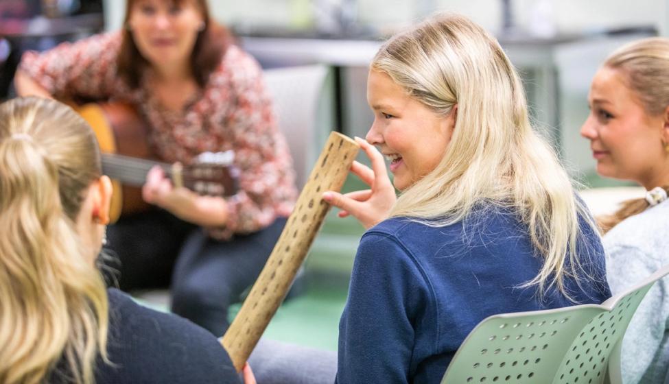 Bilde av en lærer som synger med elevene sine