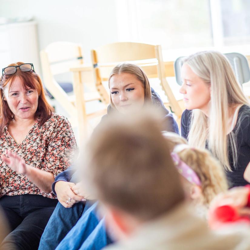 Bilde av en vgs lærer sammen med barn og elever