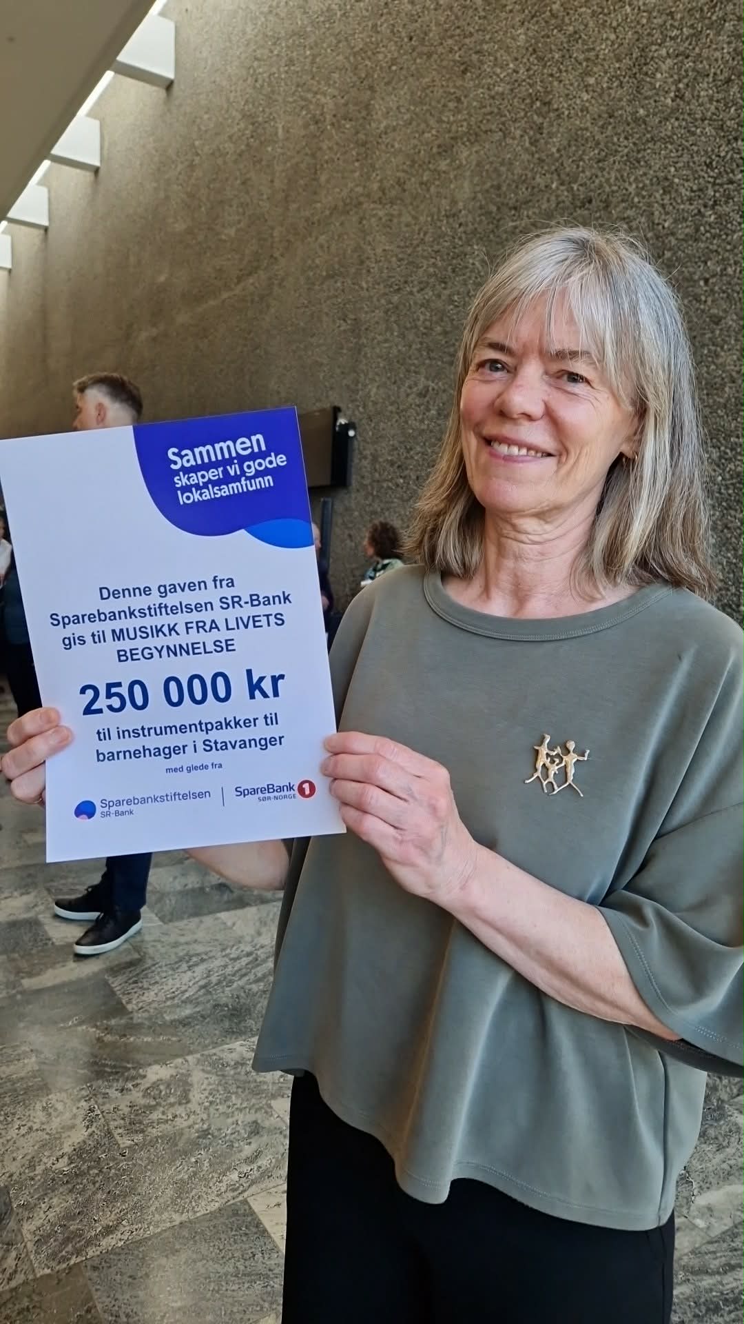 Bilde av daglig leder som viser frem diplomet fra Sparebankstiftelsen