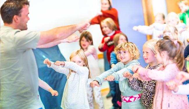 Bilde av elever som danser sammen med en lærer